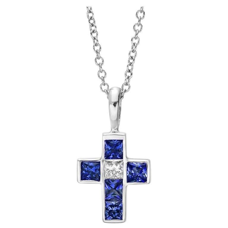 Small blue sapphire and diamond cross pendant in polished 18k white gold.
 

- Five square-cut sapphires weighing 0.40 total carats
- Square-cut diamond weighing 0.06 carats
- 18k white gold bale
- 0.62