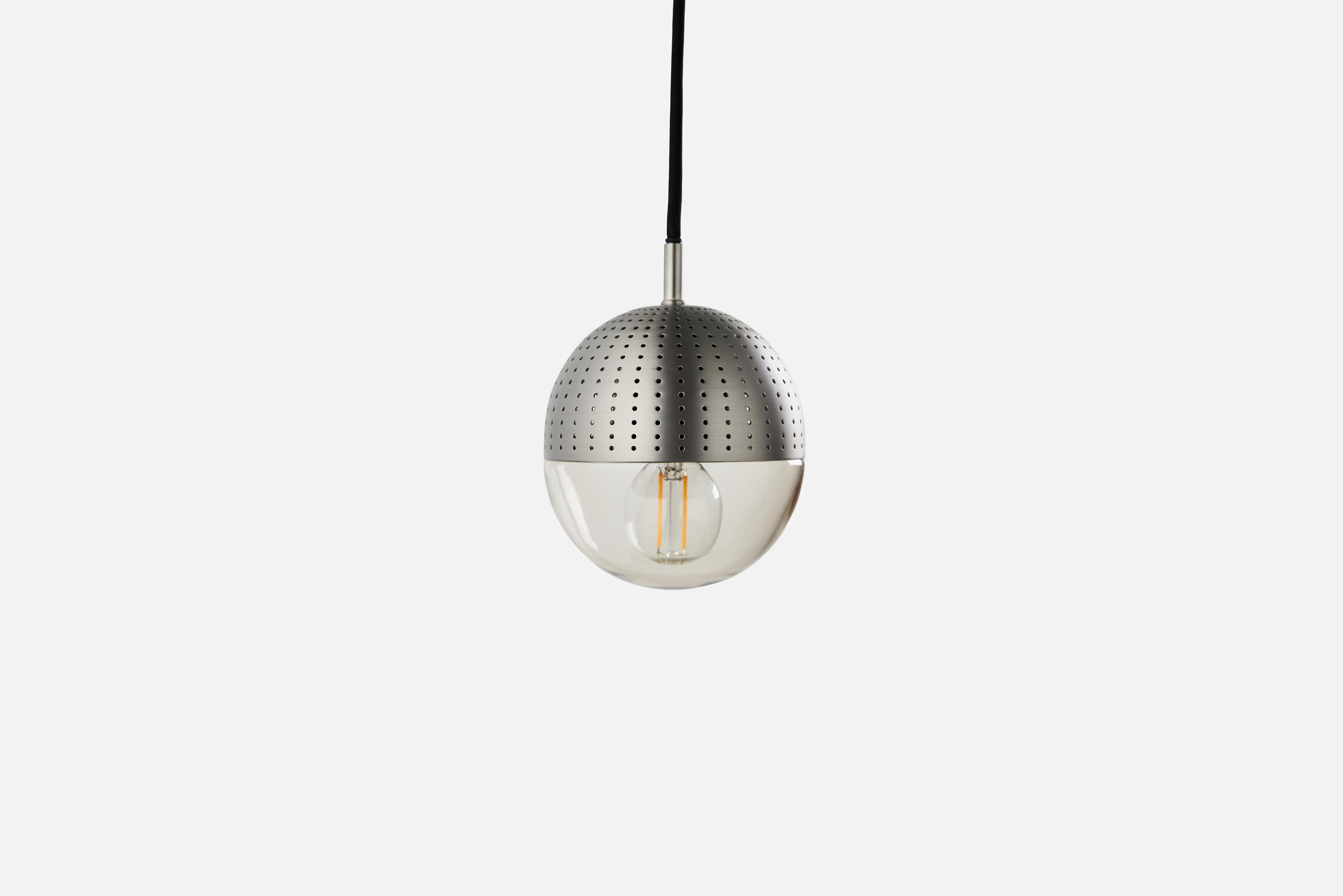 Small Satin dot pendant lamp by Rikke Frost
Materials: Metal, glass.
Dimensions: D 14 x H 13 cm
Available in black or satin and in 3 sizes: H 13, H 16.6, H 21 cm.

Rikke Frost is a Danish graduate from the School of Architecture Aarhus. Since