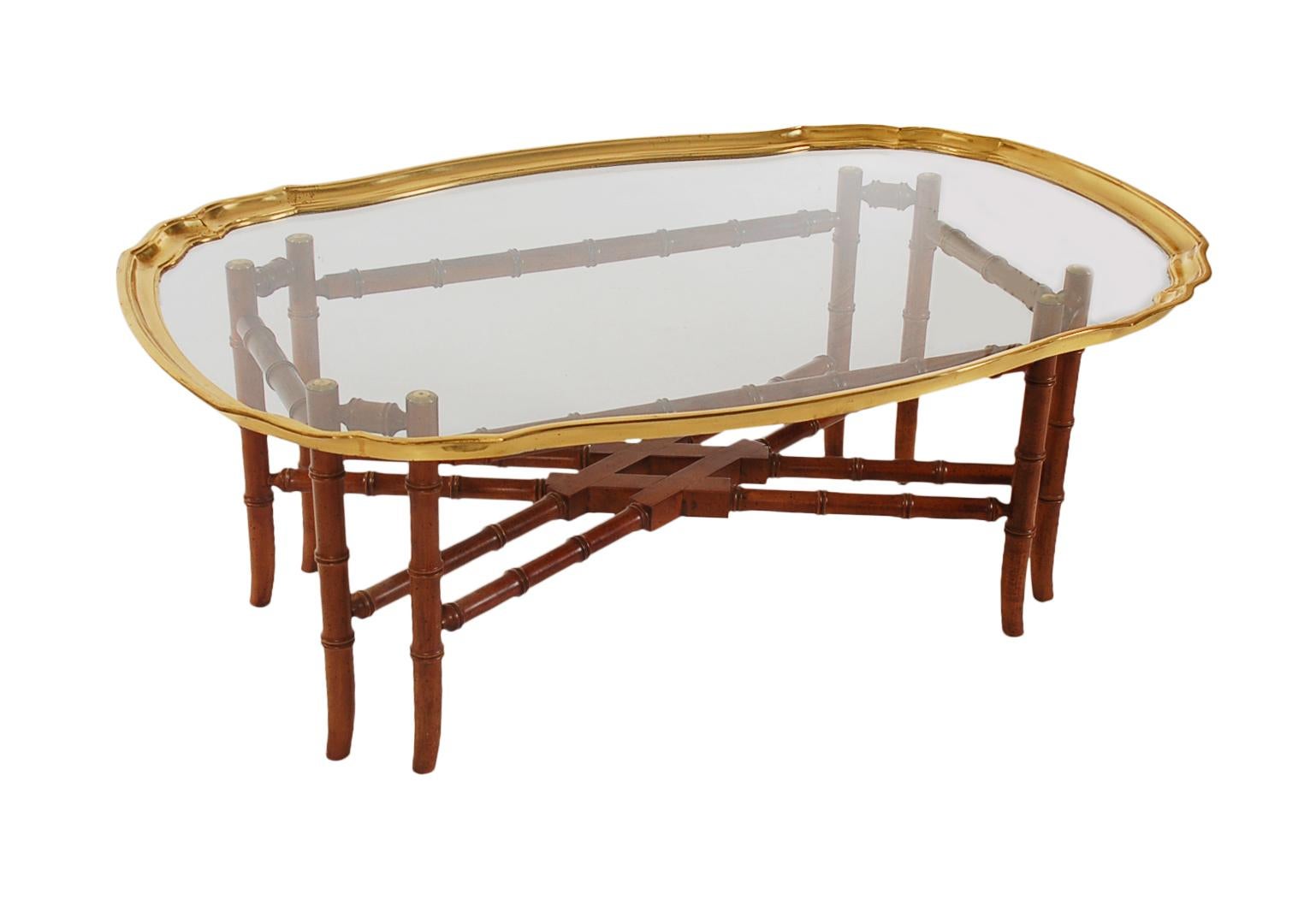 A smaller scale coffee table from the 1970s attributed to Baker Furniture. It features a solid wood bamboo form base, with a brass framed glass top. Very clean and ready for use.