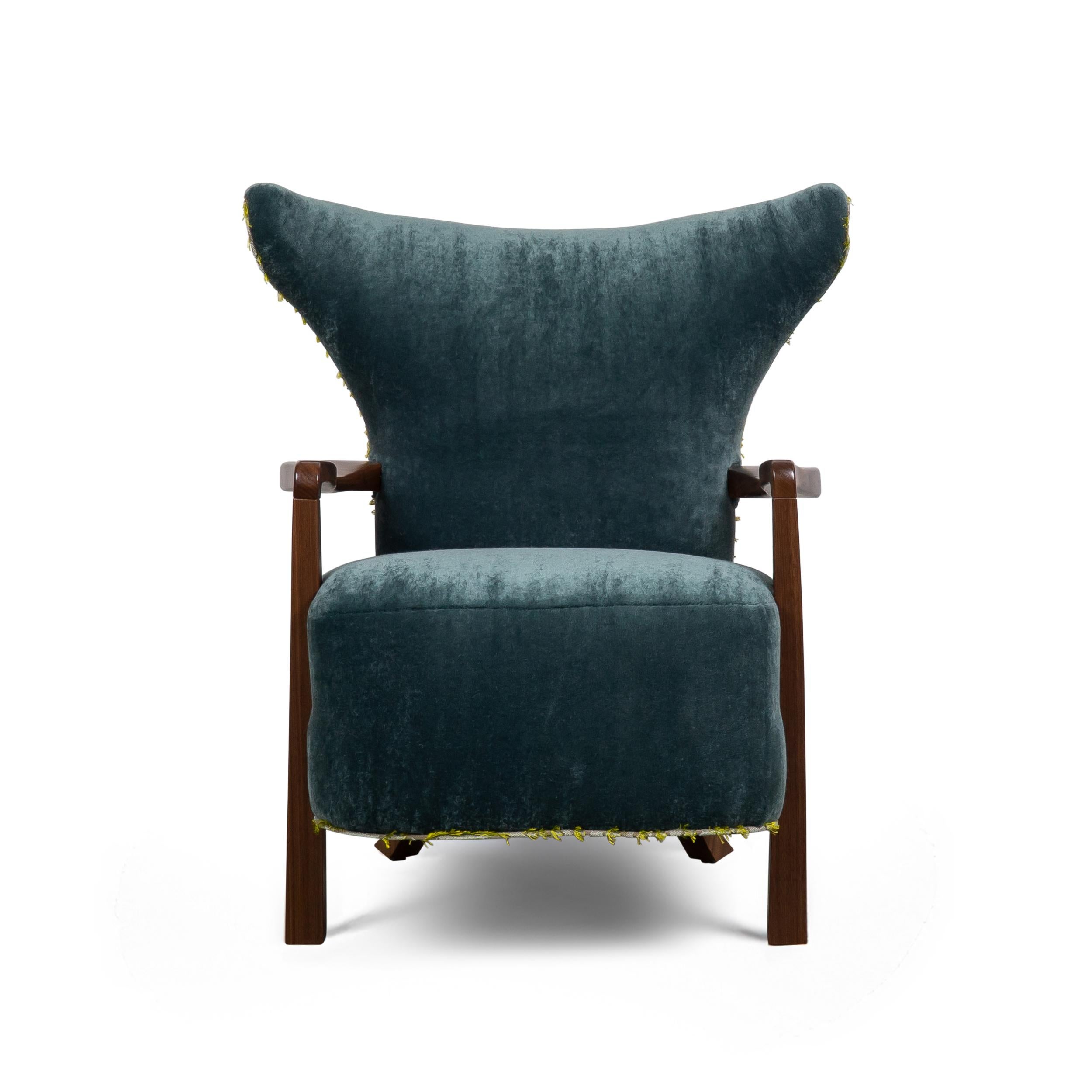 Sedia da club o poltrona di piccole dimensioni con braccioli e gambe in noce. Schienale a botte sottilmente alato e seduta stretta. Telaio costruito con acero duro massiccio e molle a otto vie legate a mano e schiuma ad alta densità. Mostrato con un