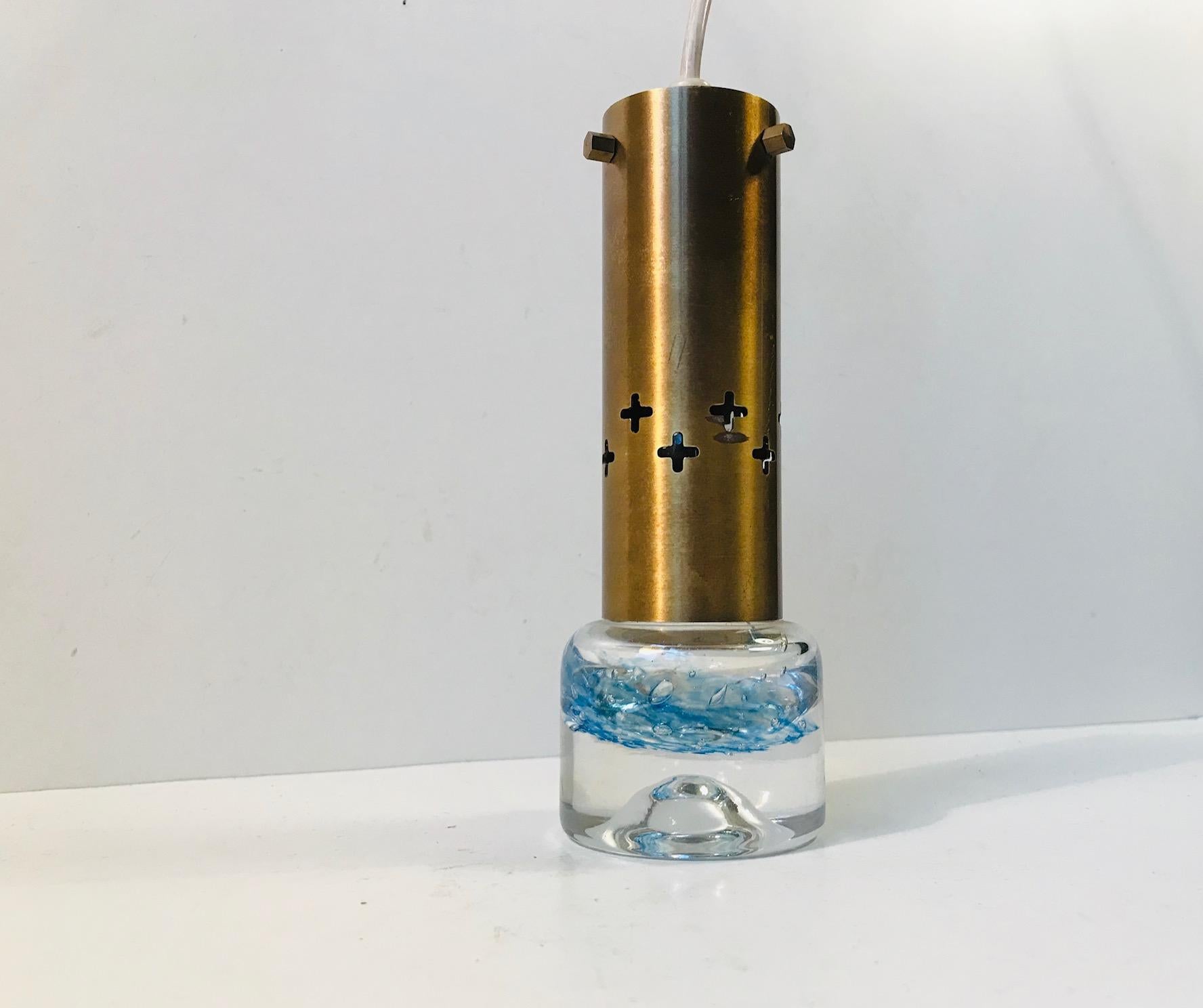Insolita lampada a sospensione composta da ottone massiccio parzialmente perforato e vetro artistico spesso. Anonimo produttore o designer scandinavo nello stile di Orrefors e Murano.