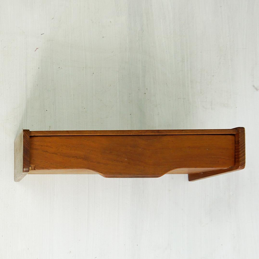 This amazing Scandinavian Modern Teak Floating shelve was designed and manufactured in Denmark in the 1960s. it can be wall mounted and used as a bedside table or nightstand or as wall console.  
This small piece of furniture is a true testament to