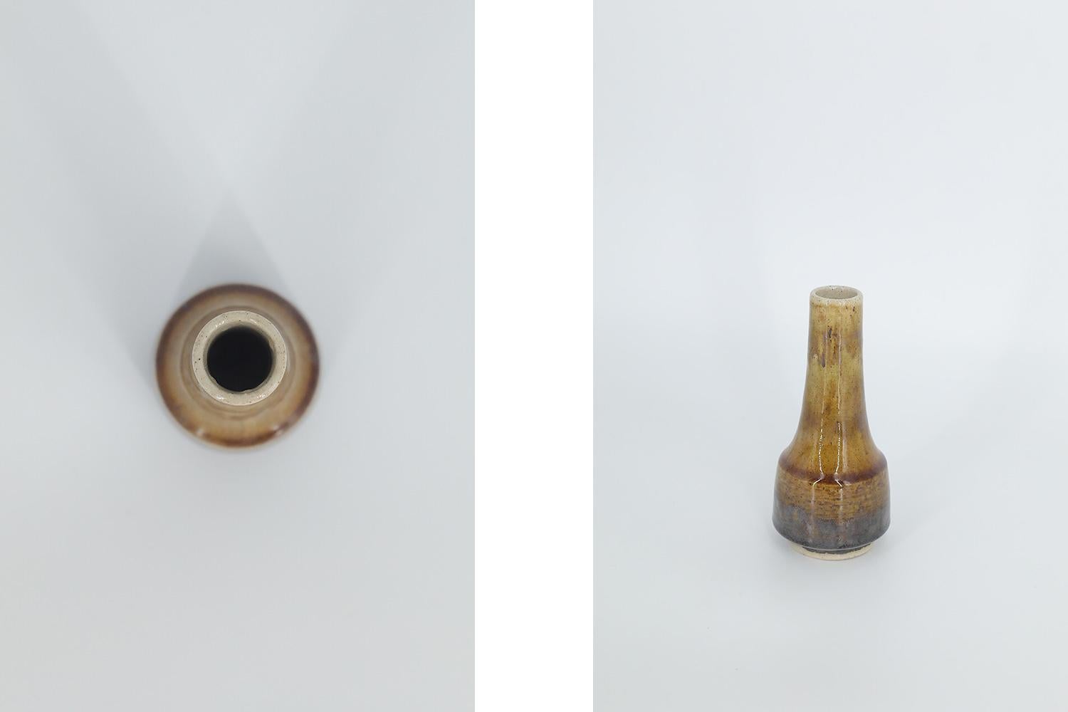 This miniature, collectible stoneware vase was designed by Gunnar Borg for the Swedish manufacture Höganäs Keramik during the 1960s. Handmade by a Master, with the utmost care and attention to details. The vase in brown and earthy colors. Glazed.