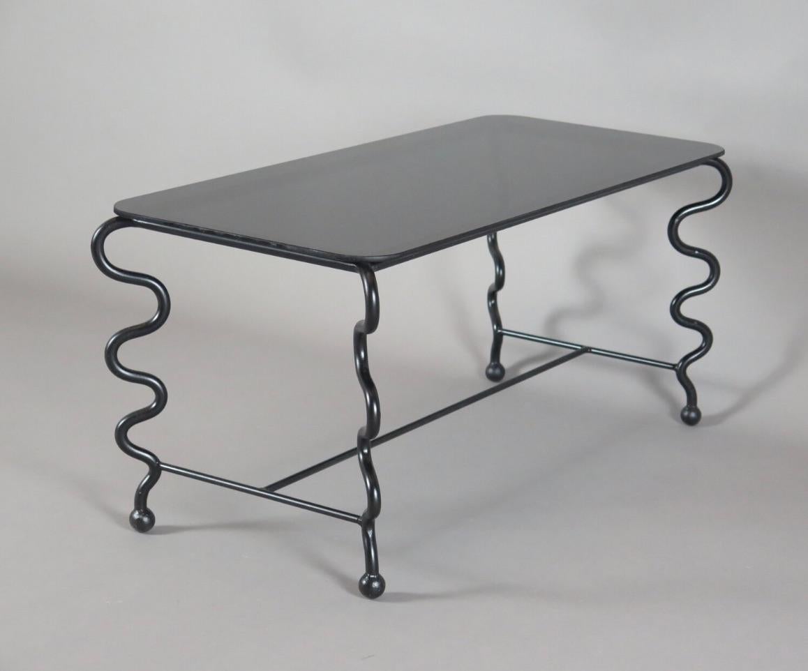 Contemporary hand-forged 'Serpentine' coffee table by Matthew Sidow.

Black wrought iron base with undulating legs and black glass top. Each piece is handmade by our skilled artisans in the United States.

Please inquire for customization requests.