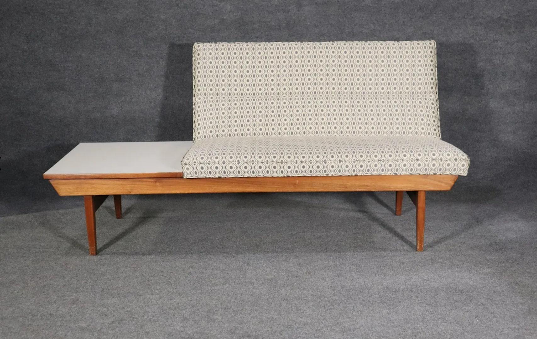 Mid-Century Modern bench with attached table. Made by Thayer Coggin with upholstered settee on a wood bench.
Please confirm location.