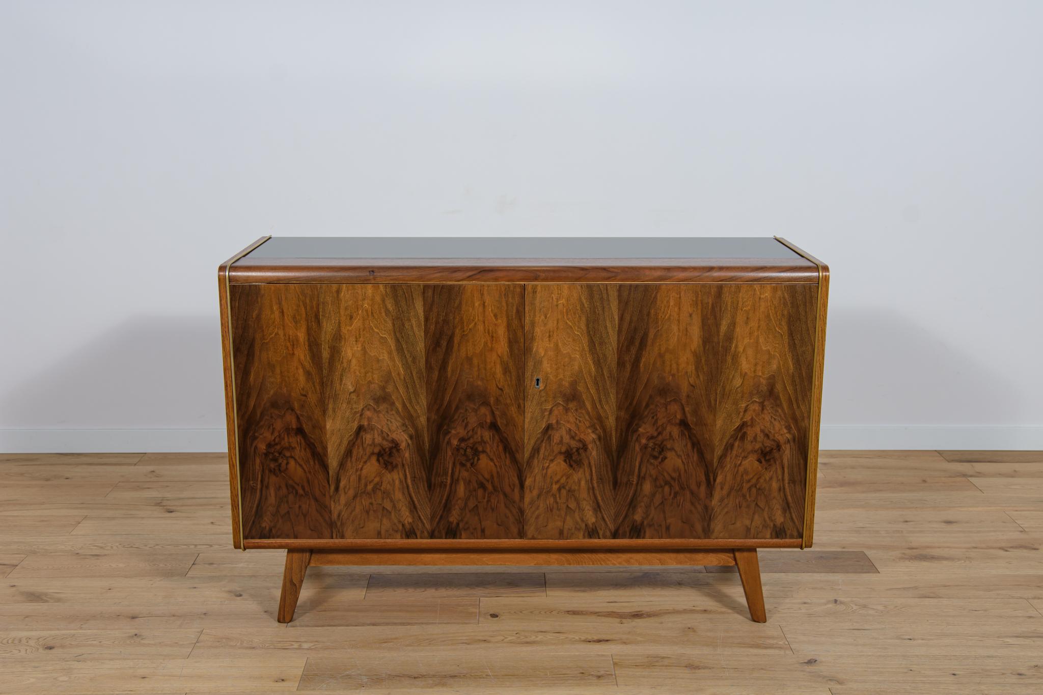 The small sideboard was designed by Bohumil Landsman and Hubert Nepozitek in the 1960s. It was manufactured by the Jitona Soběslav furniture factory in Czechoslovakia. A sideboard made of beech wood, veneered with walnut (front and top) and oak