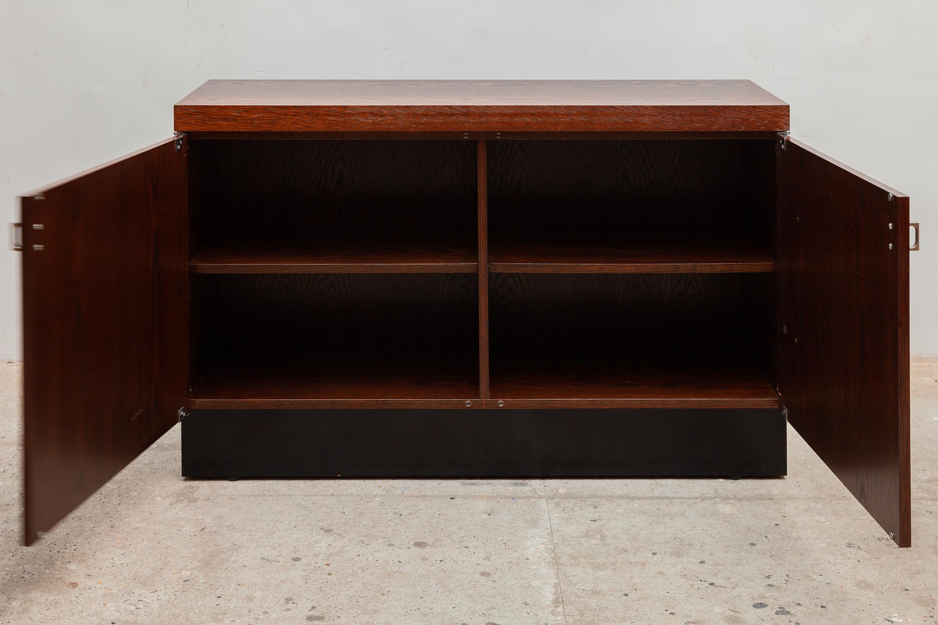 Vintage Mid-century credenza by De Coene, Belgium. Rich stained oak with floating black base. The back is fully finished and can be shown. Cabinet with shelves and magnetic door closures.
A functional design and according to modulations standard