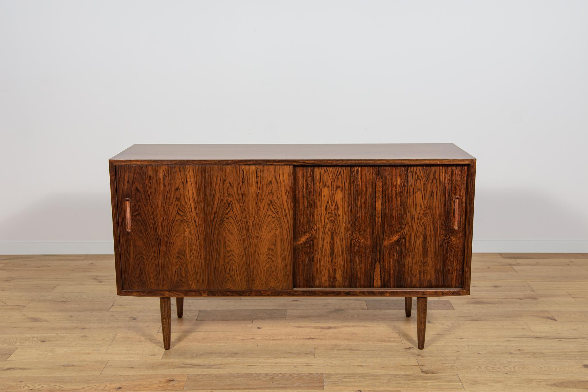 Dieses kleine Sideboard wurde in den 1960er Jahren von Poul Hundevad entworfen. Er wurde von der Möbelfabrik Hundevad & Co in Dänemark hergestellt. Sideboard mit zwei Schiebetüren, innen mit verstellbaren Einlegeböden und einer Schublade. Die Möbel