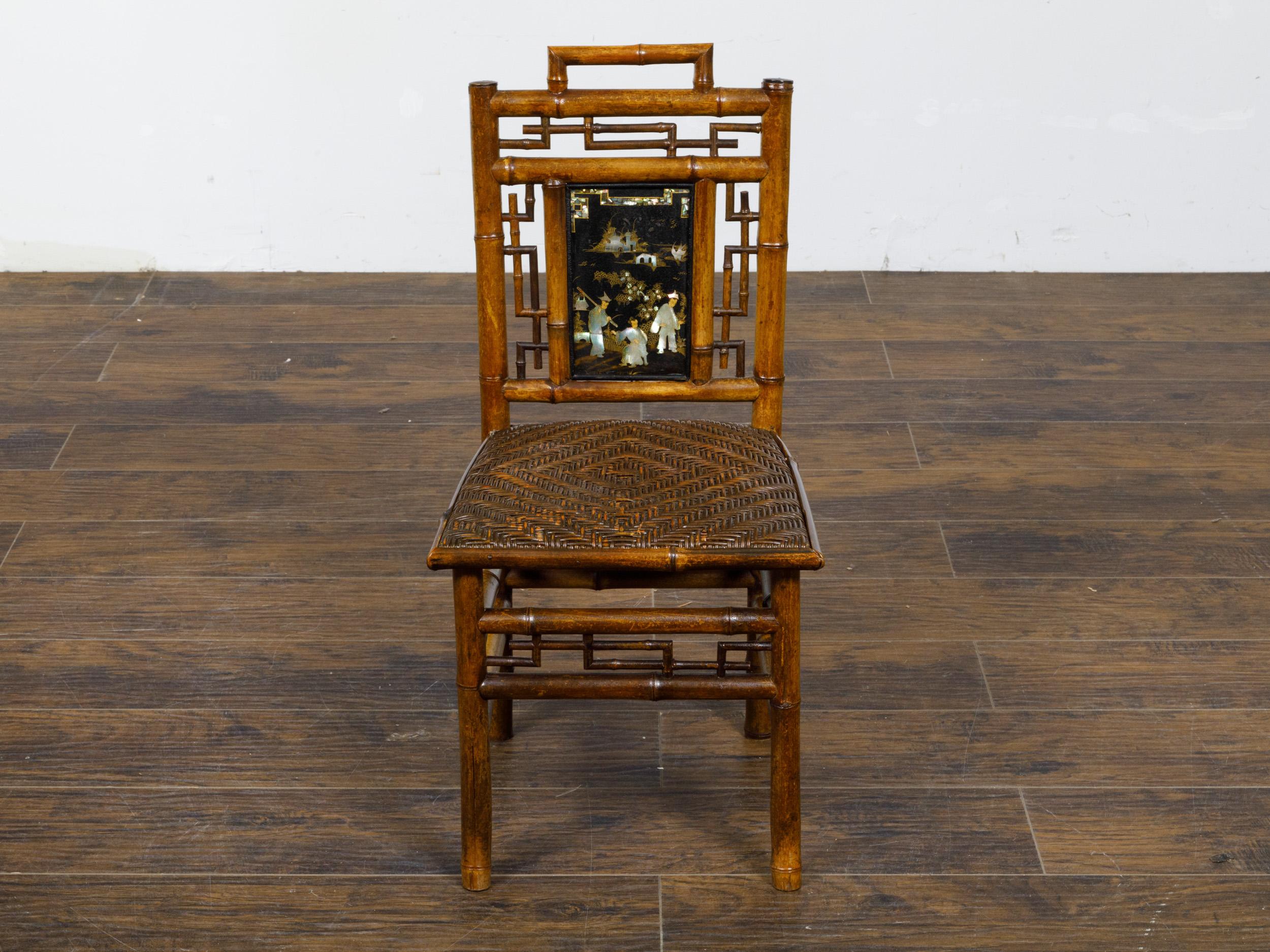 A small signed Perret et Vibert Chinoiserie bamboo chair from the late 19th century with mother of pearl inlaid black lacquered plaque on the back splat and rattan seat. Discover the exquisite craftsmanship and historical allure of this charming