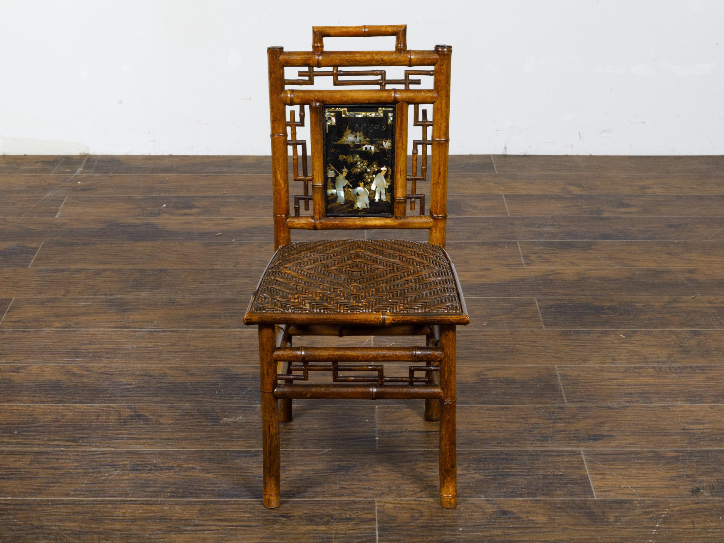 Petite chaise en bambou signée Perret et Vibert Chinoiserie de la fin du 19ème siècle avec plaque laquée noire incrustée de nacre sur le dossier et l'assise en rotin. Découvrez le savoir-faire exquis et l'allure historique de cette charmante chaise