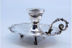 Small silver paddle with a shell-shaped base and resting on three feet