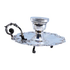 Small silver paddle with a shell-shaped base and resting on three feet