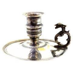 Small silver paddle with raised trim and applications on the cut-out handle