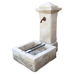 Petite fontaine autoportante à pilier unique en pierre calcaire sculptée de Provence, France