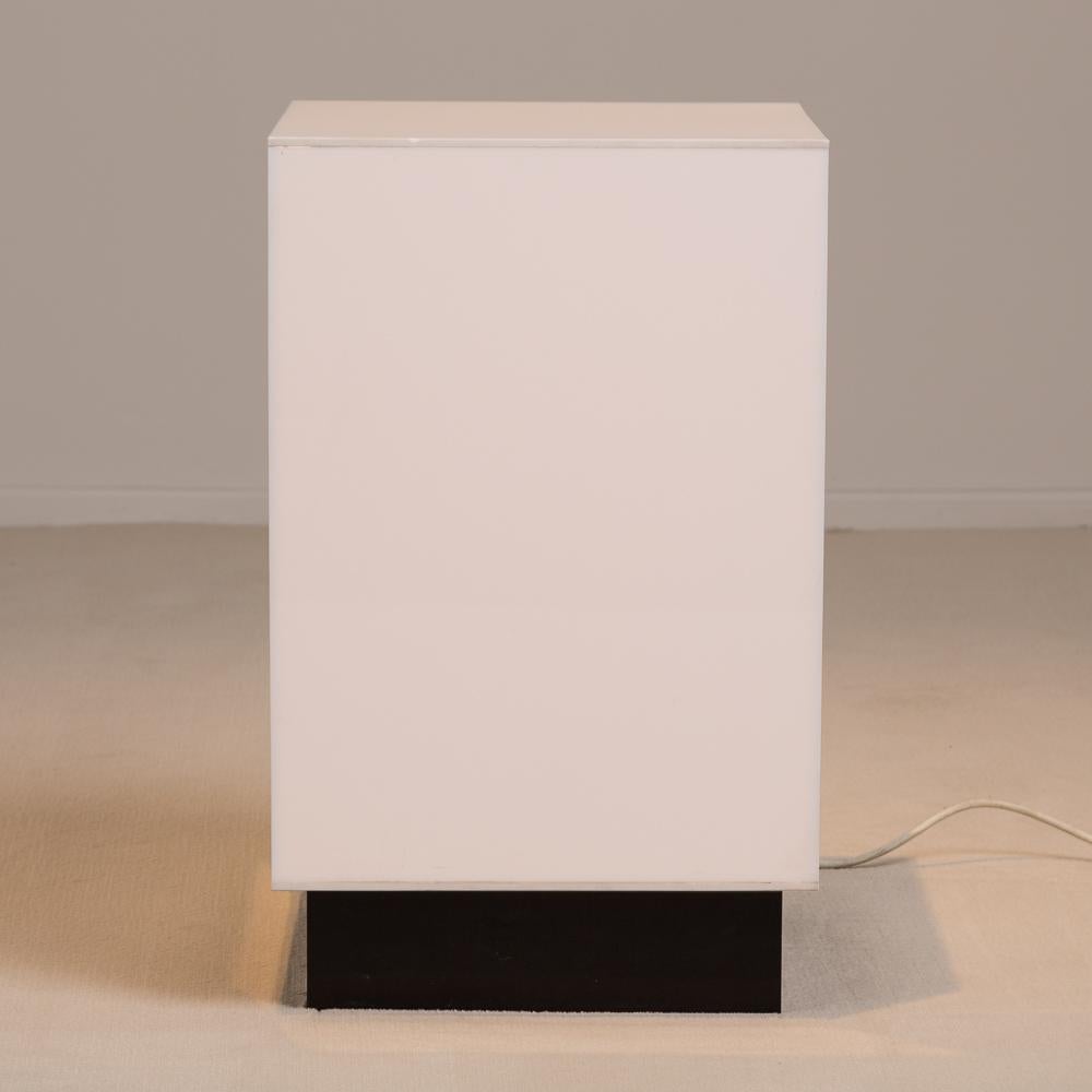 Small single white acrylic light box side table on a black plinth USA 1970s.