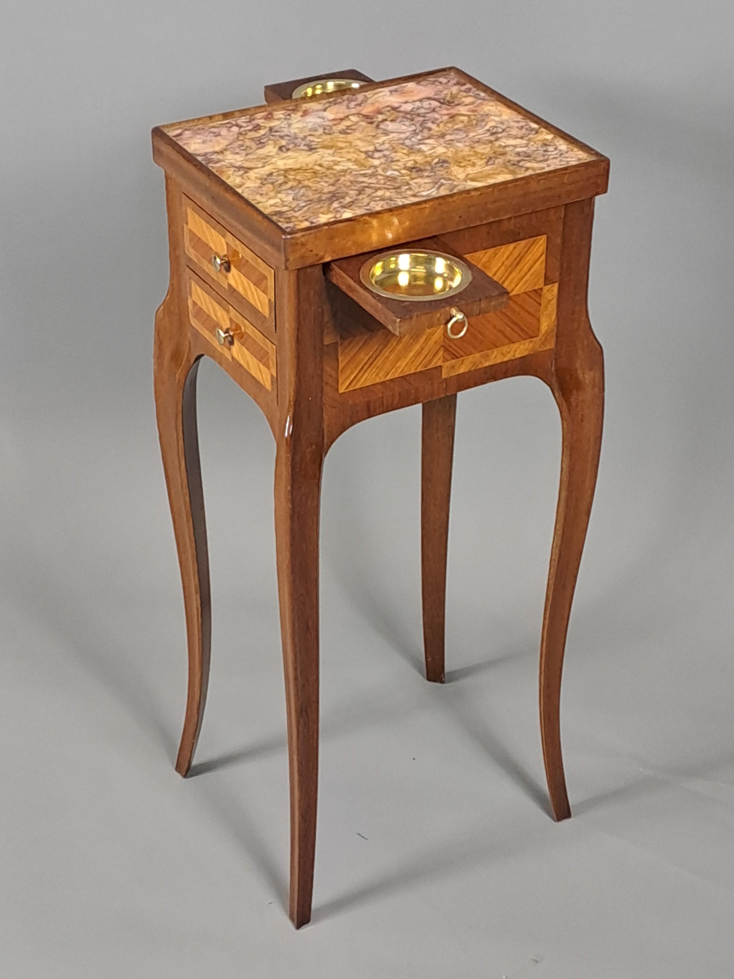 Elegante tavolino da salotto chiamato tavolo del fumatore in palissandro e intarsio di palissandro in stile transitorio.  

 L'apertura di 2 cassetti laterali e di 2 ripiani a scomparsa rivela dei posacenere in ottone.  

 Un lavoro di qualità