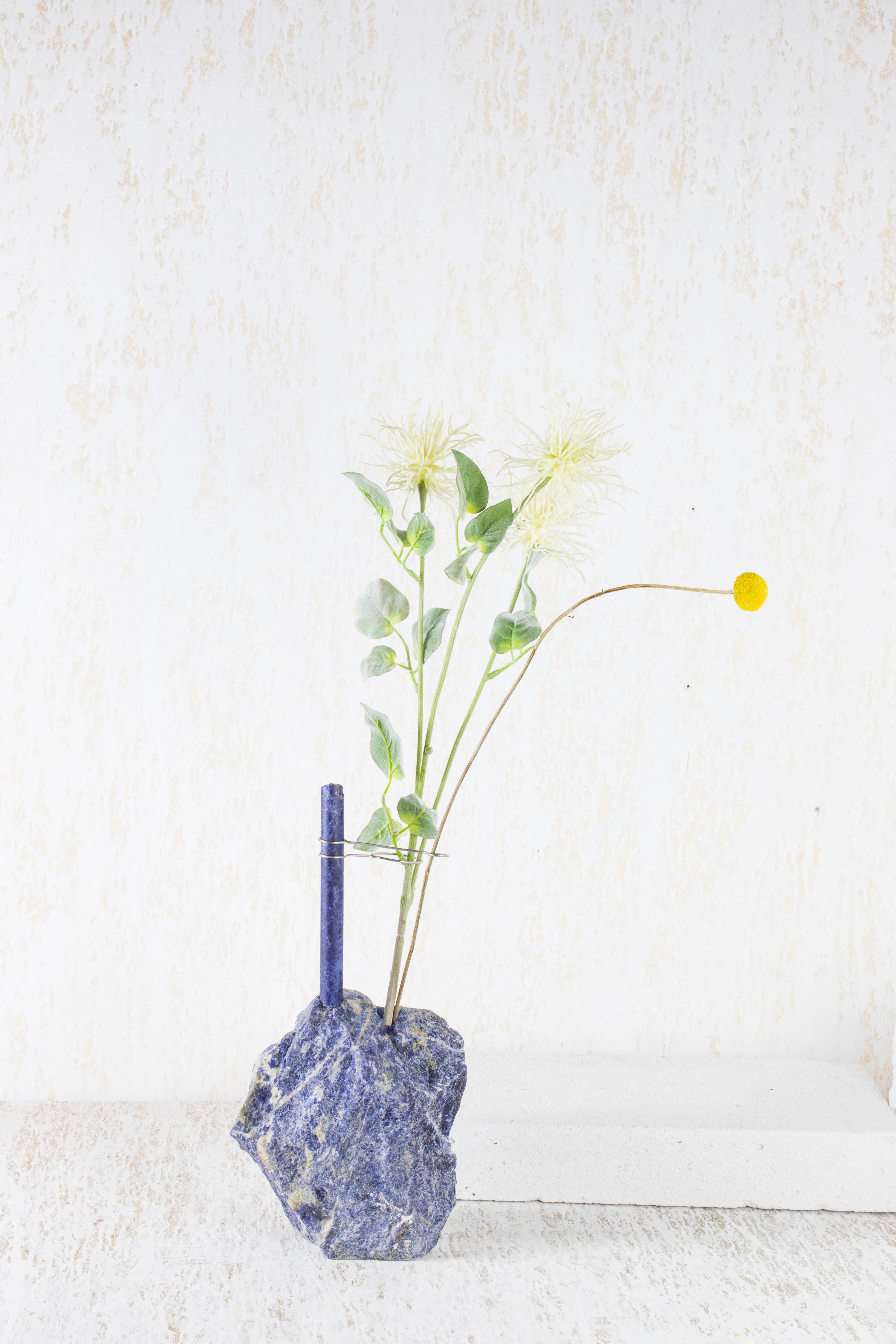 Small Sodalite Flower Vessel by Studio DO
Dimensions: D 20 x W 8 x H 36 cm
Materials: Sodalite, stainless steel.
4.5 kg.

Flowers are intrinsically connected with composition and earth.
Influenced by varied vessels from past to present such as the