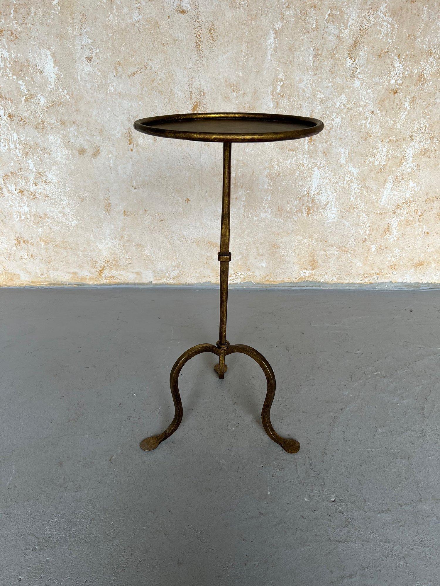 This elegant Spanish drinks table, recently handcrafted by skilled European artisans using traditional ironworking techniques, showcases a tapered central stem with decorative ring accents on a gracefully curved tripod base. Its round top features a