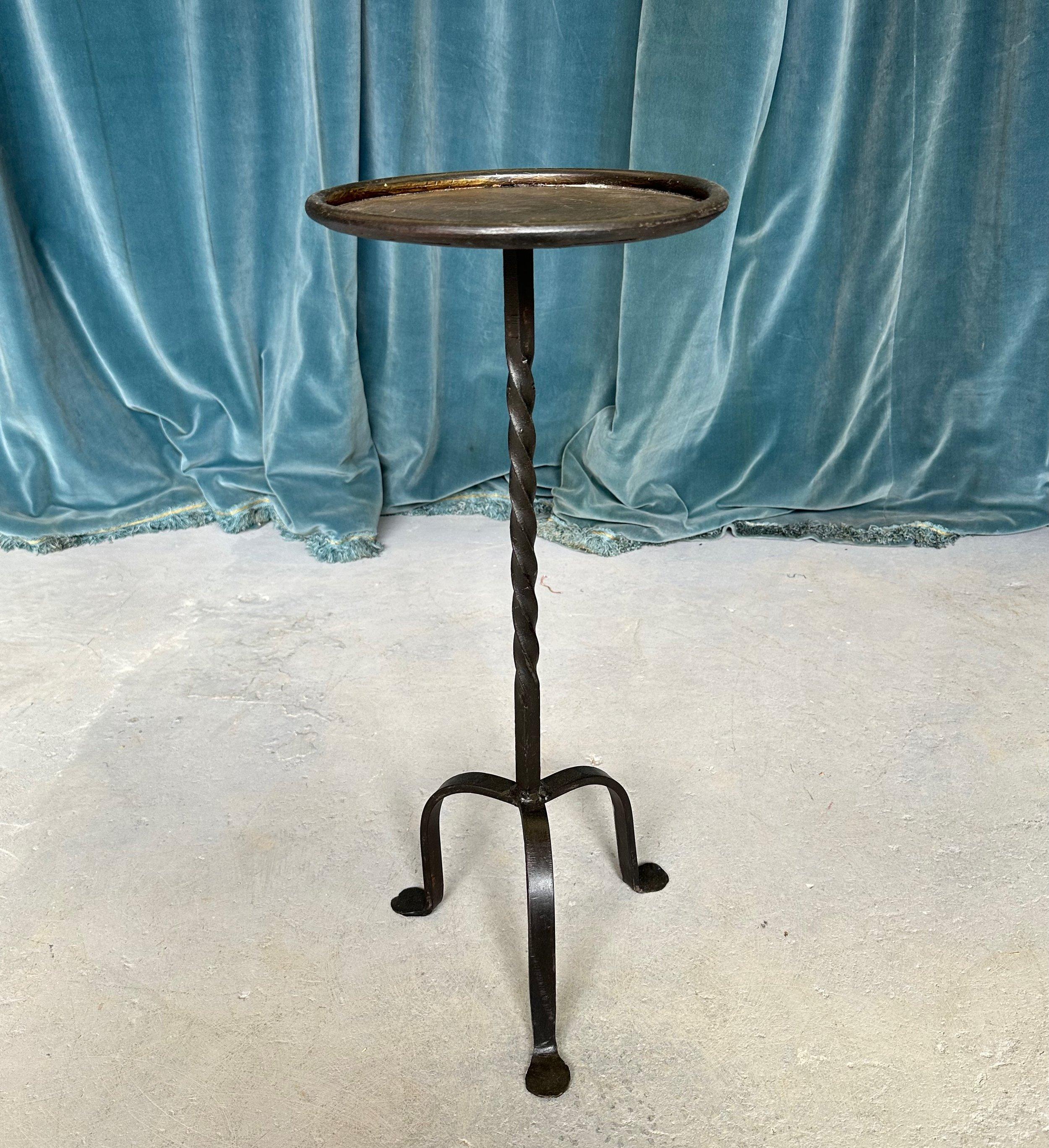 This striking Spanish drinks table was recently crafted by accomplished European artisans using traditional iron-working methods. Based on one of our favorite 1950s designs, the table has a sturdy tripod base and a twisted stem that adds visual