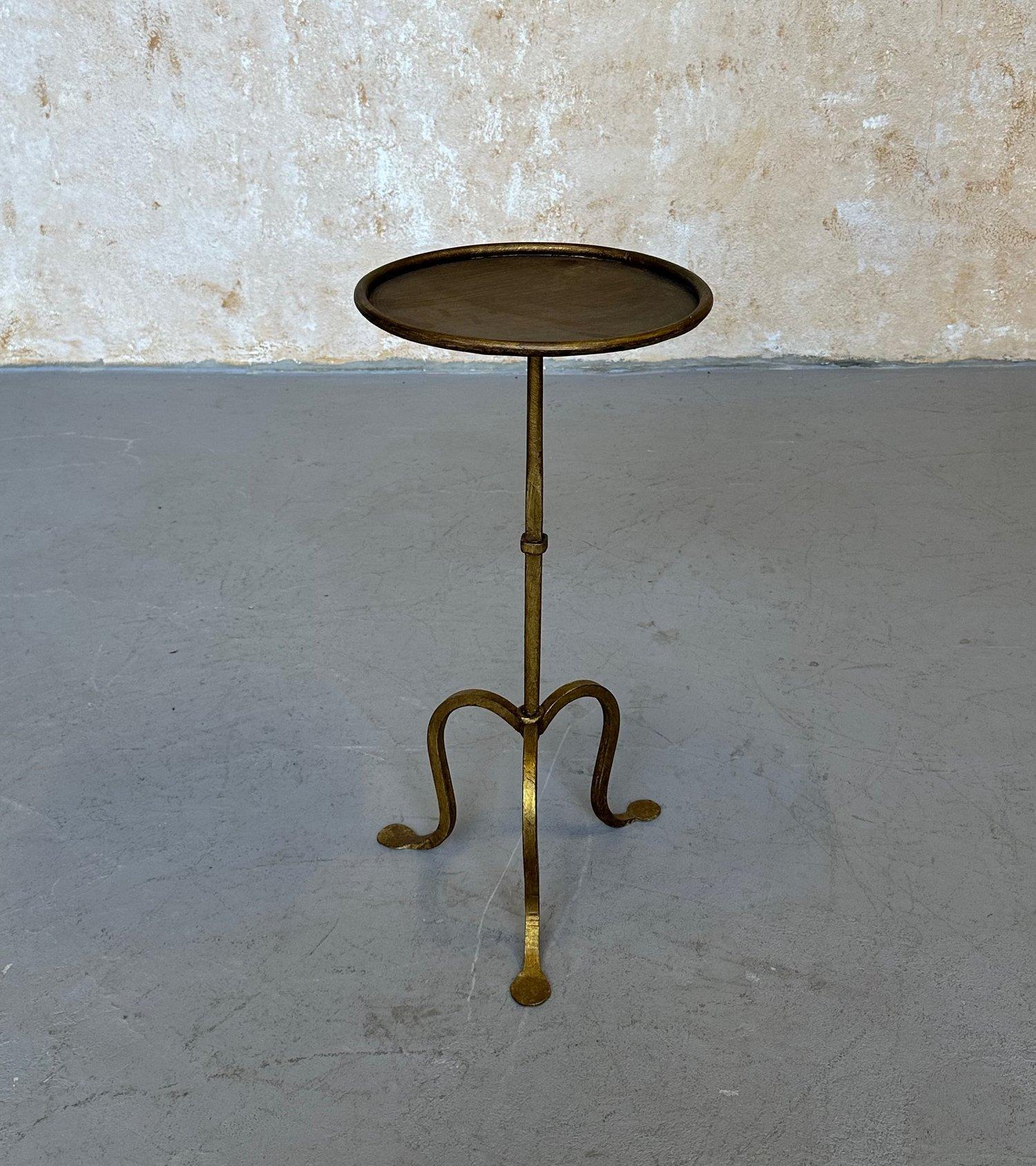 Inspired by one of our cherished vintage designs, this exquisite Spanish iron drinks table has been recently crafted to our specifications. It showcases a hand-applied gilt gold finish accented with red undertones. The stem features a central ring