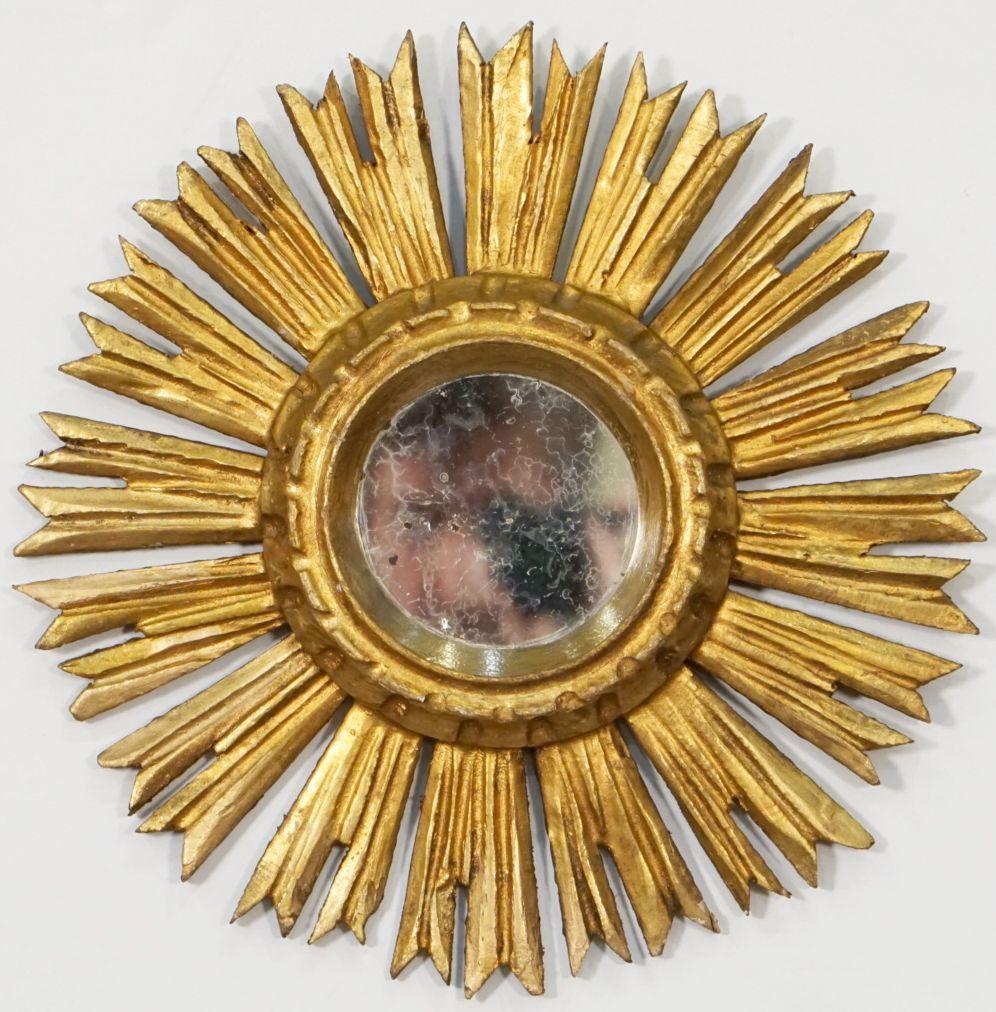 A lovely Spanish gilt sunburst (or starburst) mirror, 11 1/2 inches diameter, with round mirrored glass center in a moulded frame.