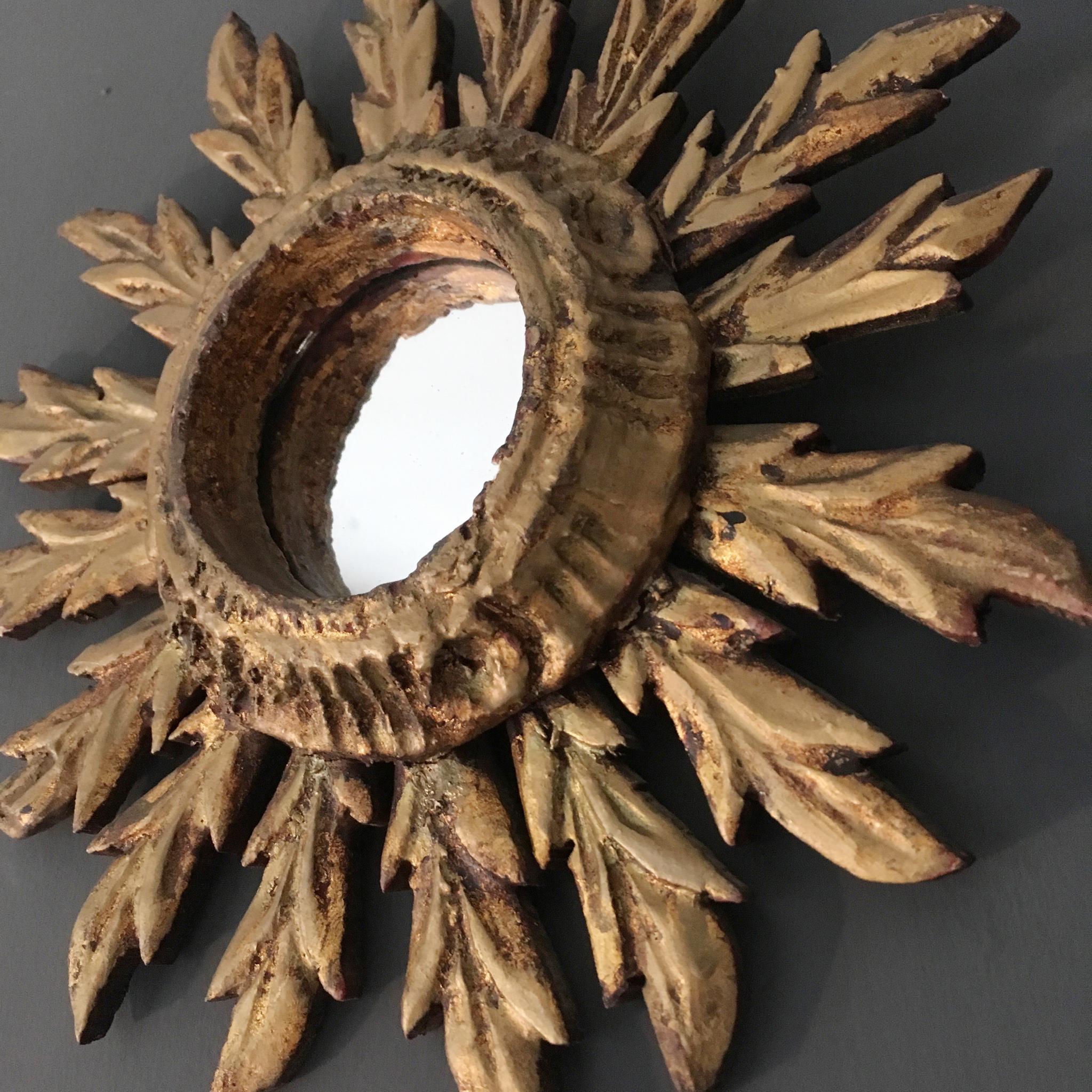 Spanish handcrafted wooden sunburst mirror

Rare small size

Feather shaped rays, 

circa 1950s

Hand carved wood with original gilt finish

Measures: 27 cm total width 
7.5 cm mirror width

Small hanging hook on reverse.