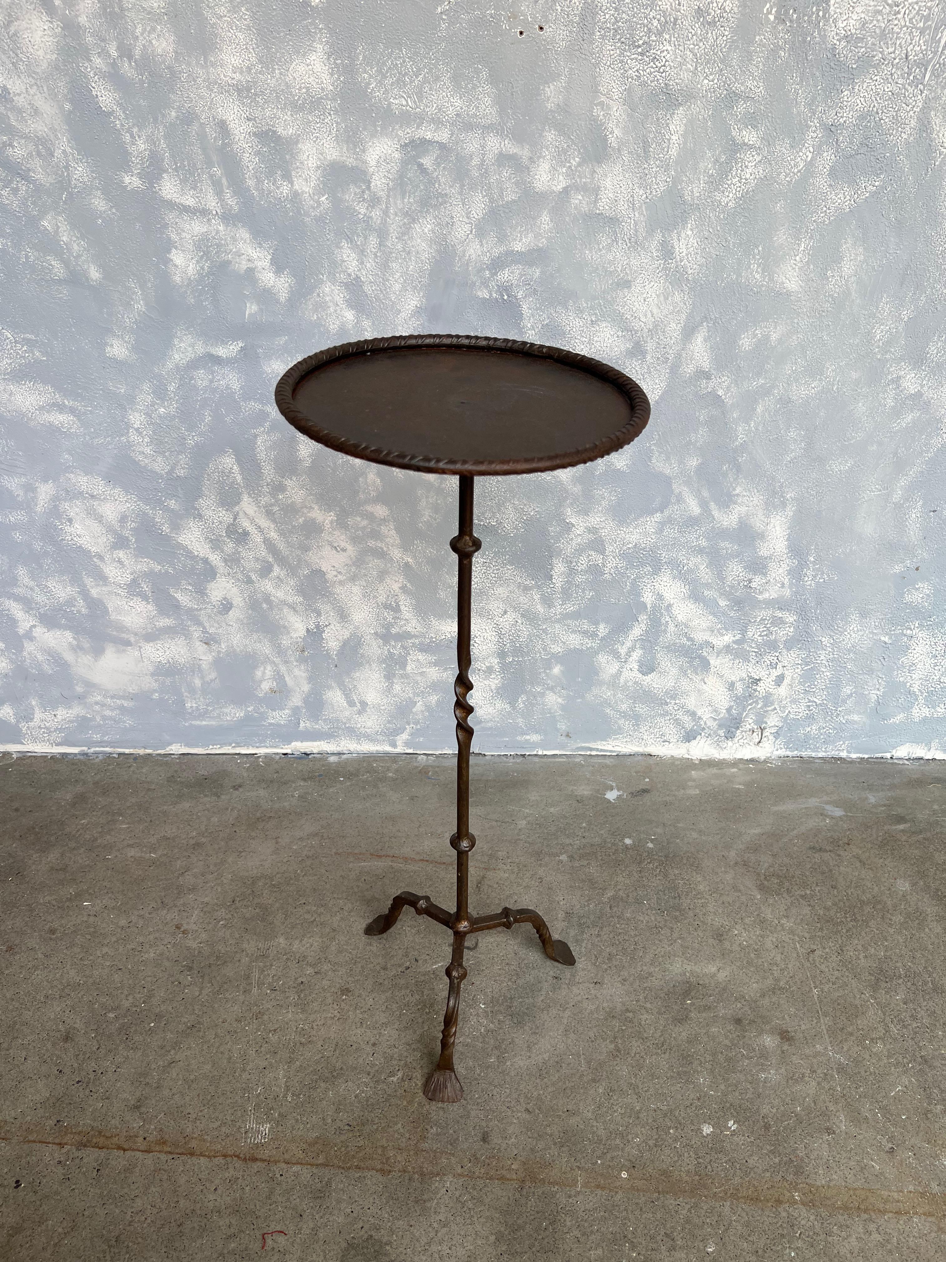 Small Spanish iron drinks table

An unusual side table made of hand wrought iron. The round metal top is framed in a tooled rim and rests on a slender stem with decorative elements and slightly twisted in the middle, and is supported on a matching