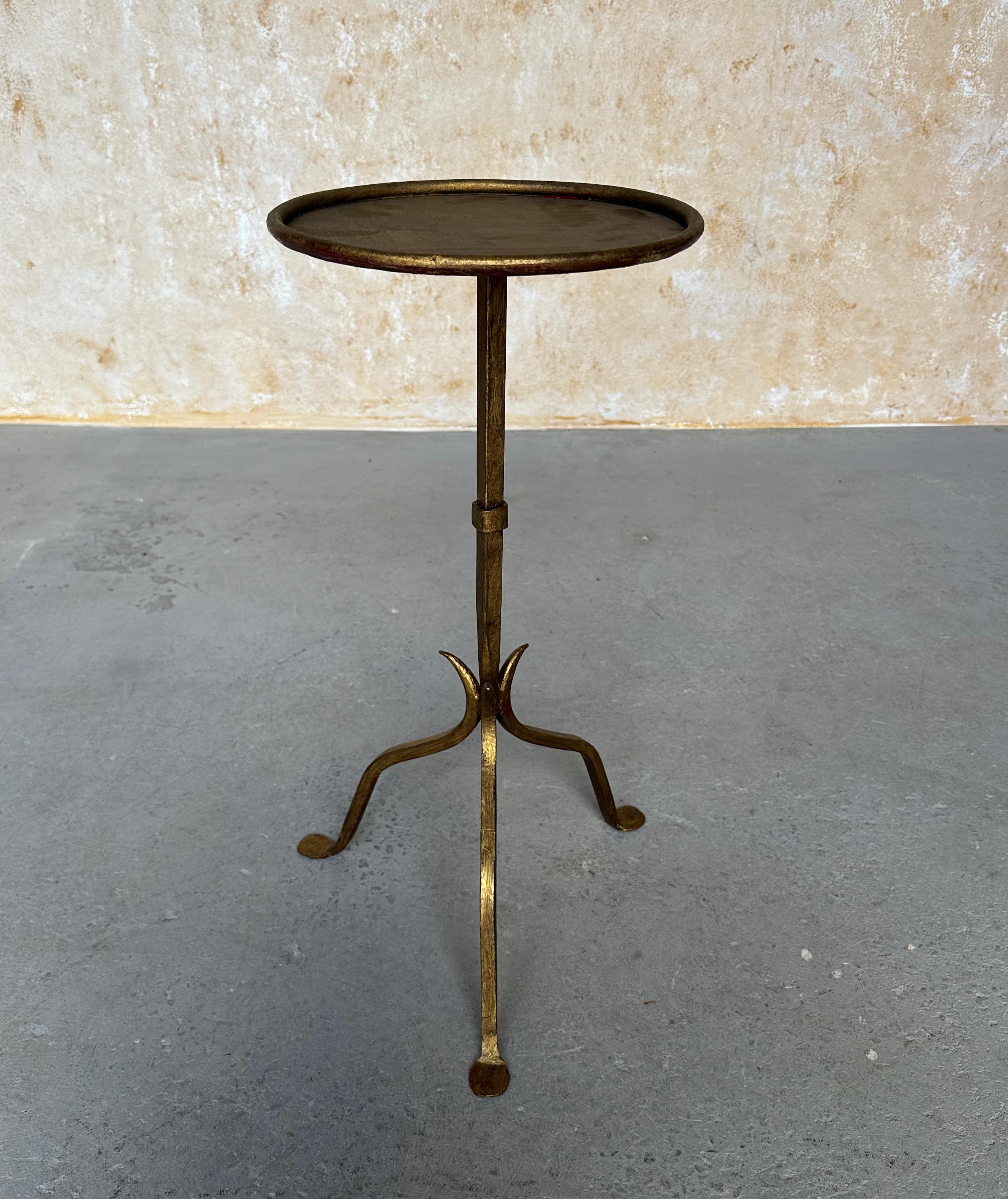This lovely Spanish iron side table was recently hand crafted by skilled artisans and features a distinctive design with a central stem that tapers to a fine point, attached to a sturdy tripod base that comprises three subtly curved legs. A rolled