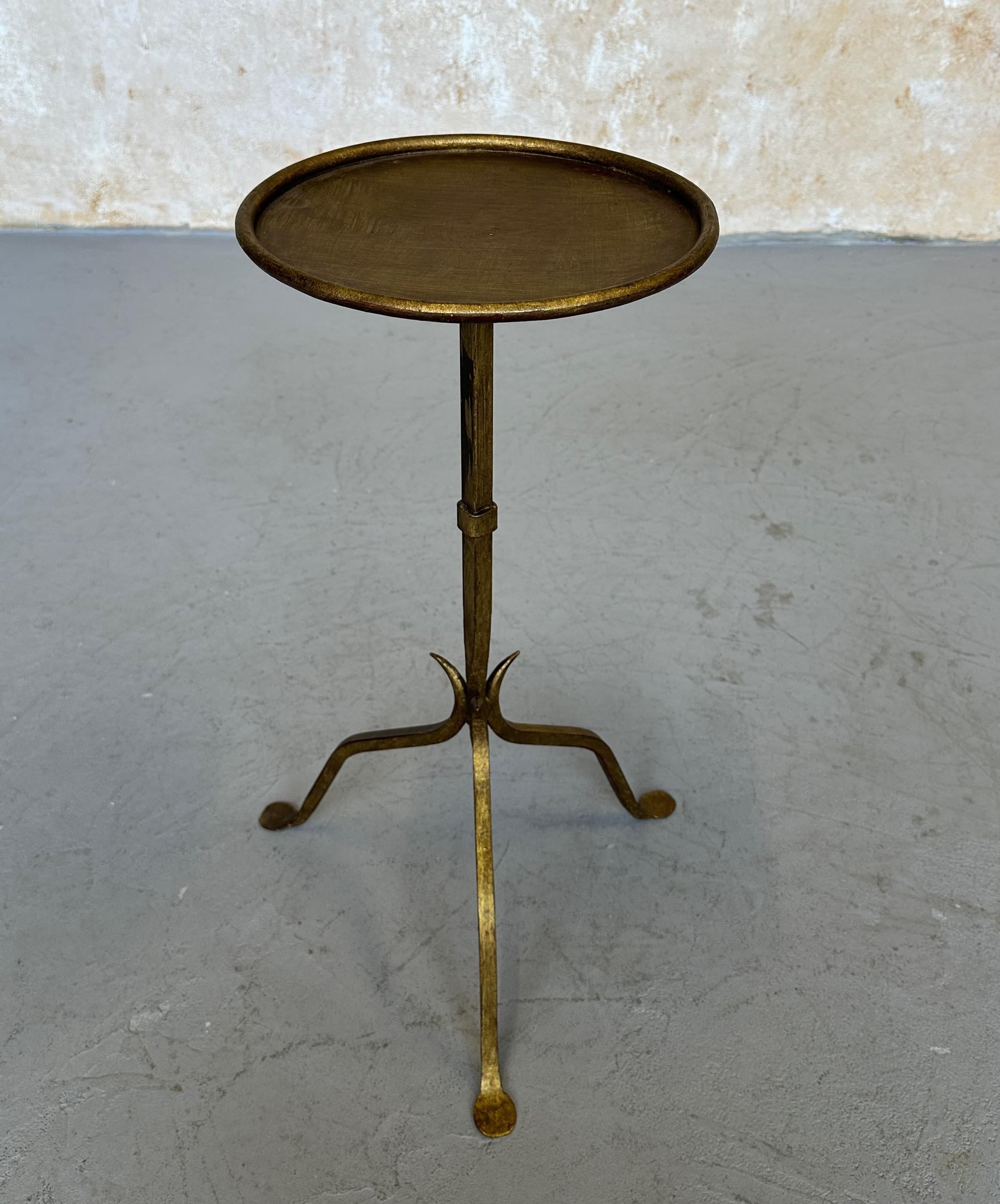 This lovely Spanish iron side table was recently hand crafted by skilled artisans and features a distinctive design with a central stem that tapers to a fine point, attached to a sturdy tripod base that comprises three subtly curved legs. A rolled