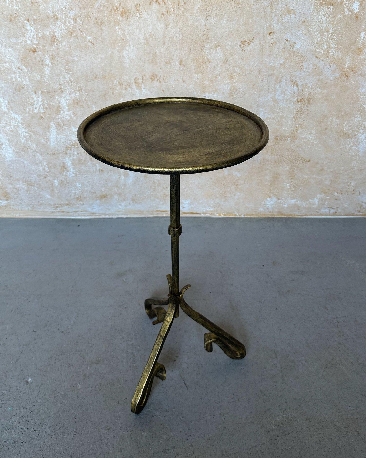 This unique small Spanish side or drinks table was recently hand crafted by skilled European artisans using traditional iron working techniques. It features a stem with a central decorative element mounted on a fanciful elevated tripod base with