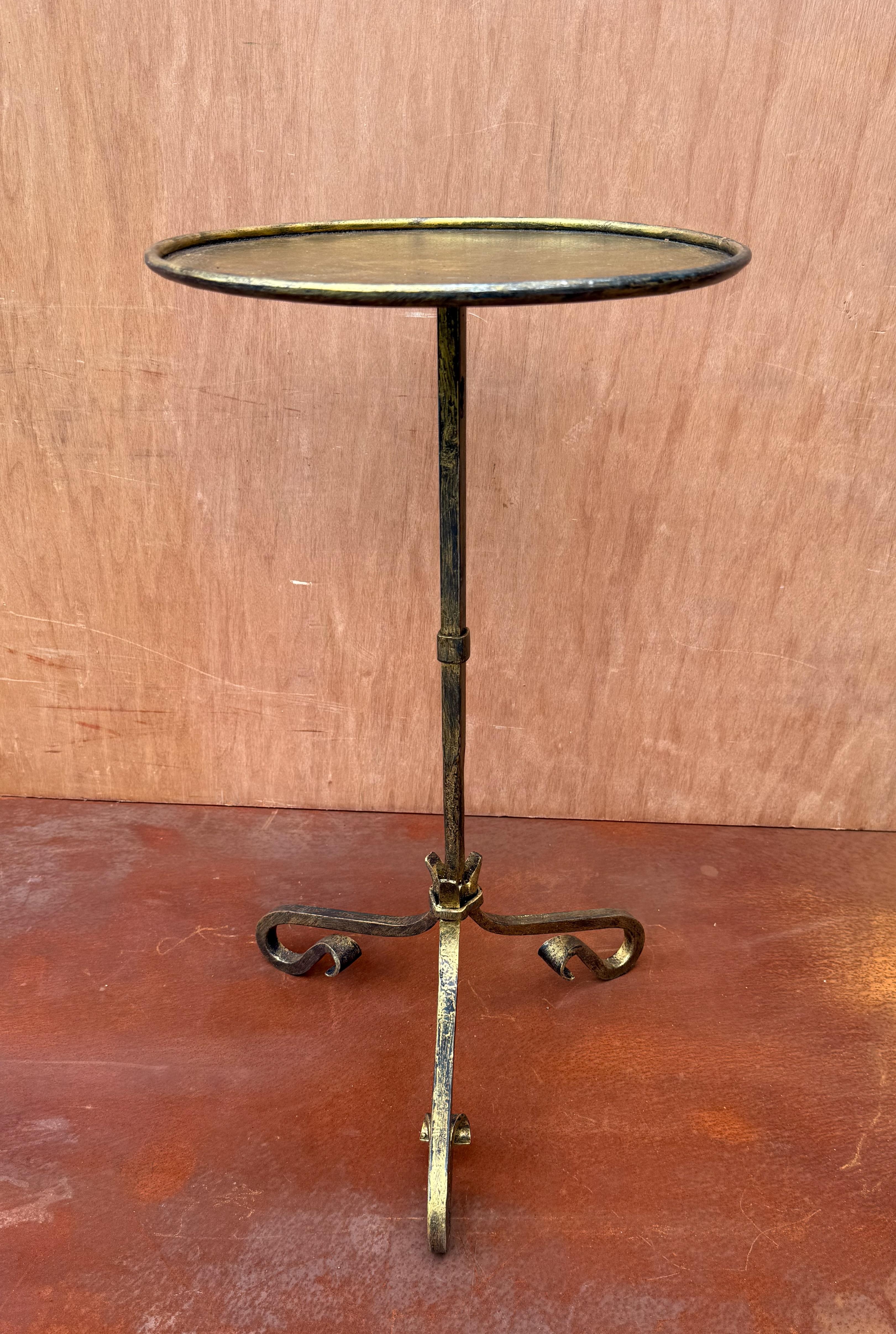 Elevate your space with this elegant, hand-crafted Spanish-style side table. Recently hand crafted by skilled European artisans using traditional iron working techniques, this charming drinks table stands on a tripod base with graceful, curved