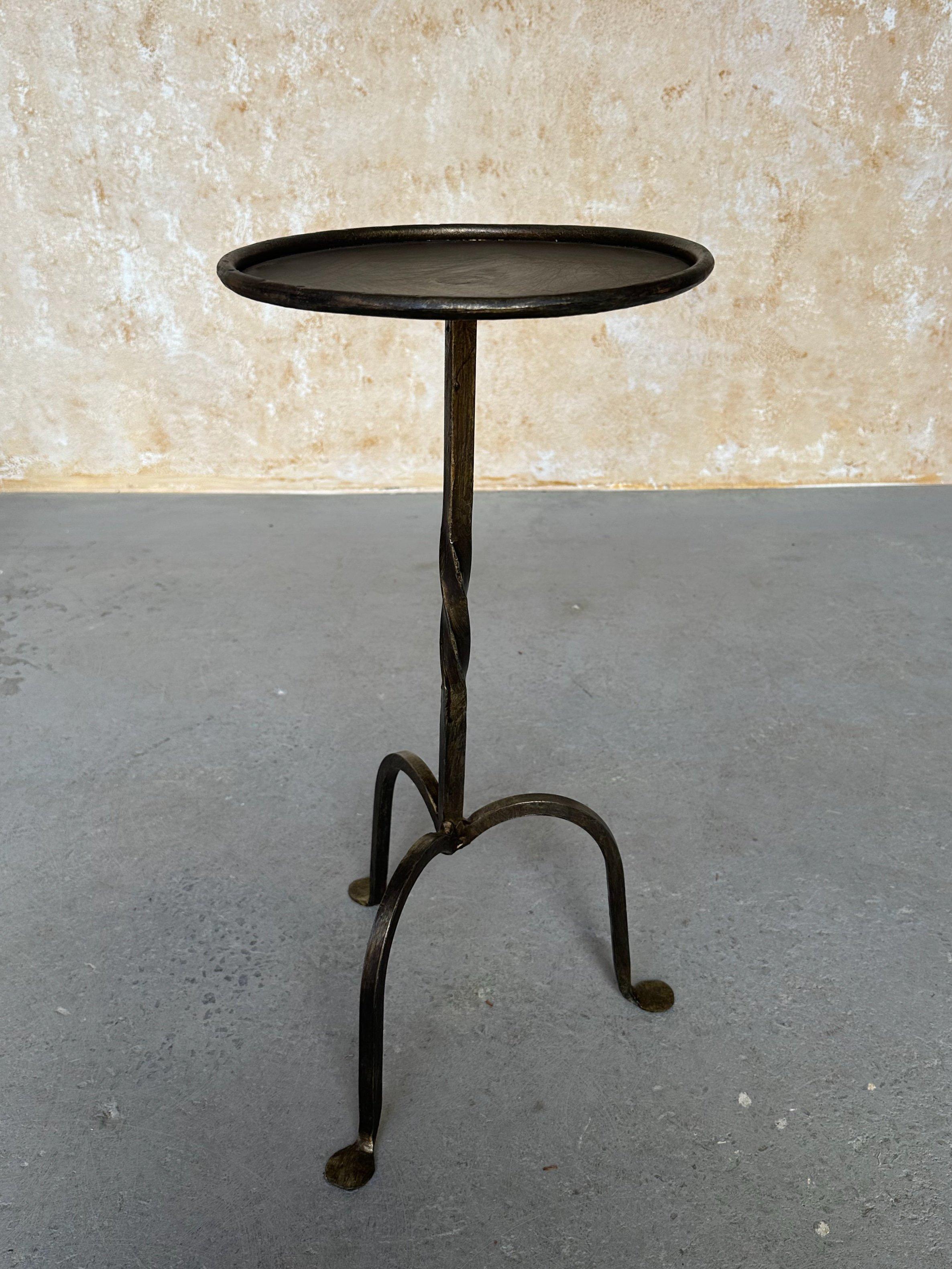 This small Spanish end table was recently created by accomplished European artisans using traditional iron-working methods. It features a central twisted stem detail and is mounted on a tripod base with gently splayed feet. Measuring 22.5 inches
