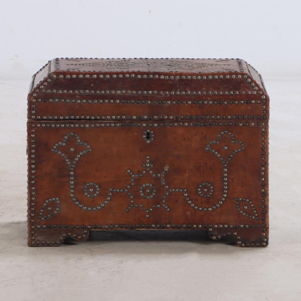 Small Spanish Studded Leather Trunk, early 19th century, with steel rivets in floral and line design on all four sides, a coffered lid, iron bail handles and a red lined interior. The perfect spot to hide away your cherished possessions.