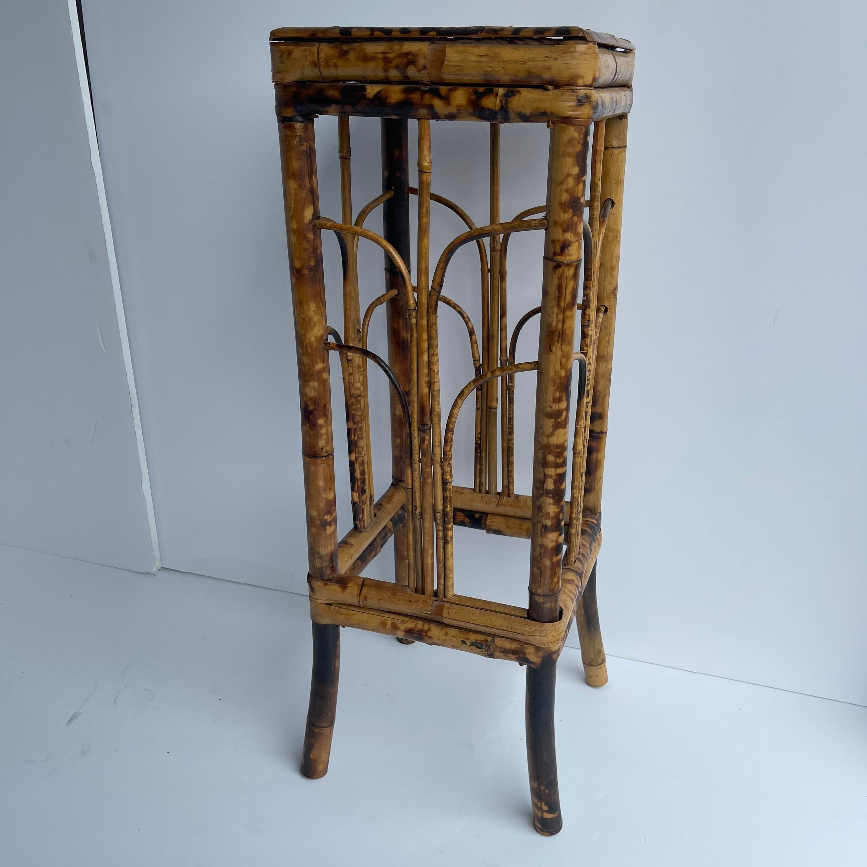 Square Mid-Century Modern bamboo rattan plant stand.
This sweet small square bamboo plant stand is sitting pretty with it's slightly flared legs and delicate decorative side panels. Sturdy and rich in color, the plant stand also makes a nice