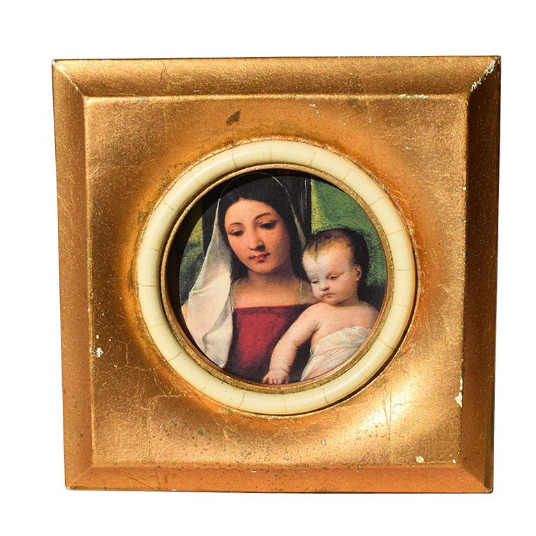 A heavy gilt gold photo frame. This frame will be great for a side table or nightstand. It is square in form and covered in a gilt gold leaf. The center of the frame has a round circular cutout with white/cream faux horn detail. 

Dimensions:
6