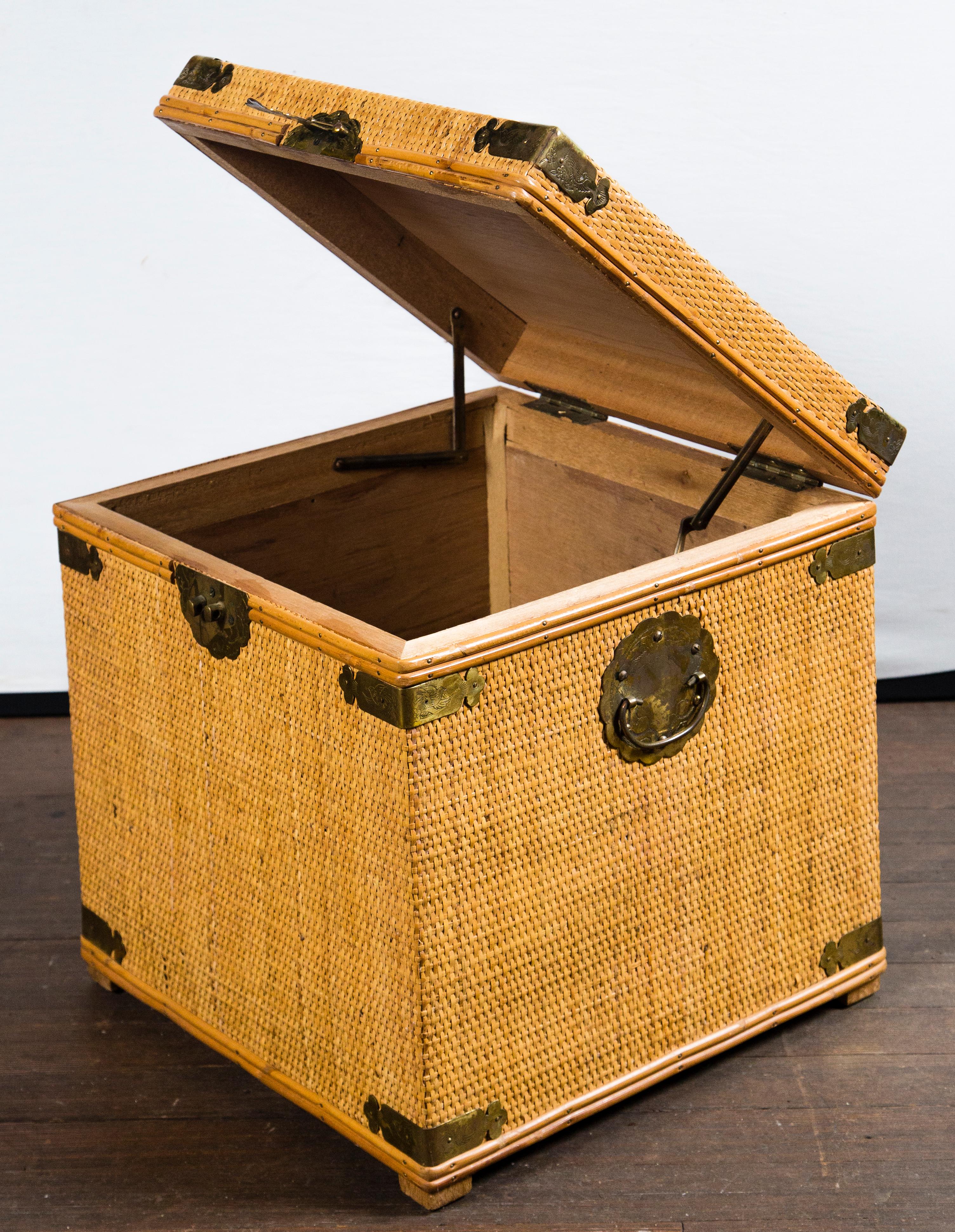 Small square rattan trunk with decorative brass trim and hardware.