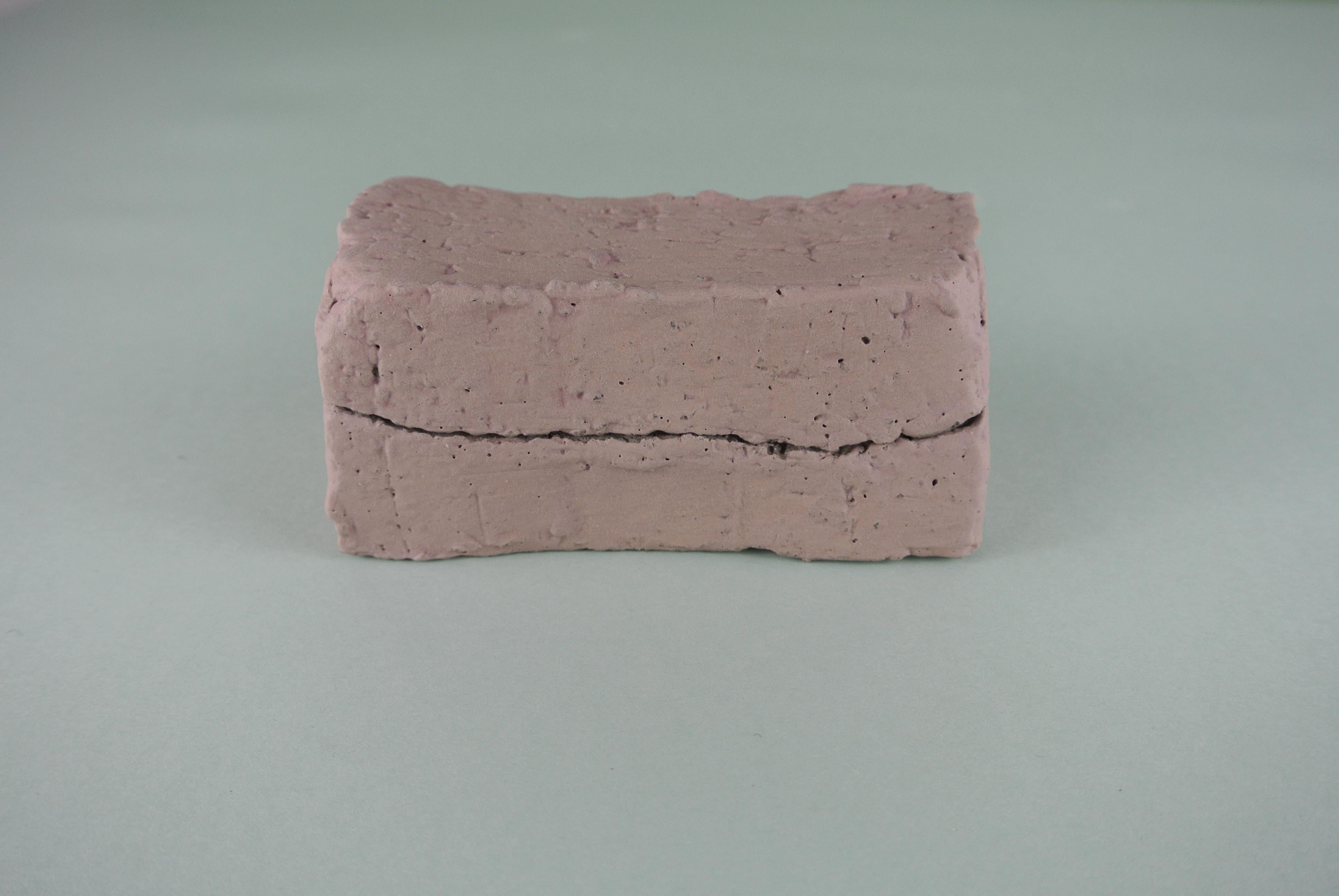 Decorative box made from rough, grey stoneware. Pale pink engobe on the outside, raw on the inside. Also available with a lichen green engobe.