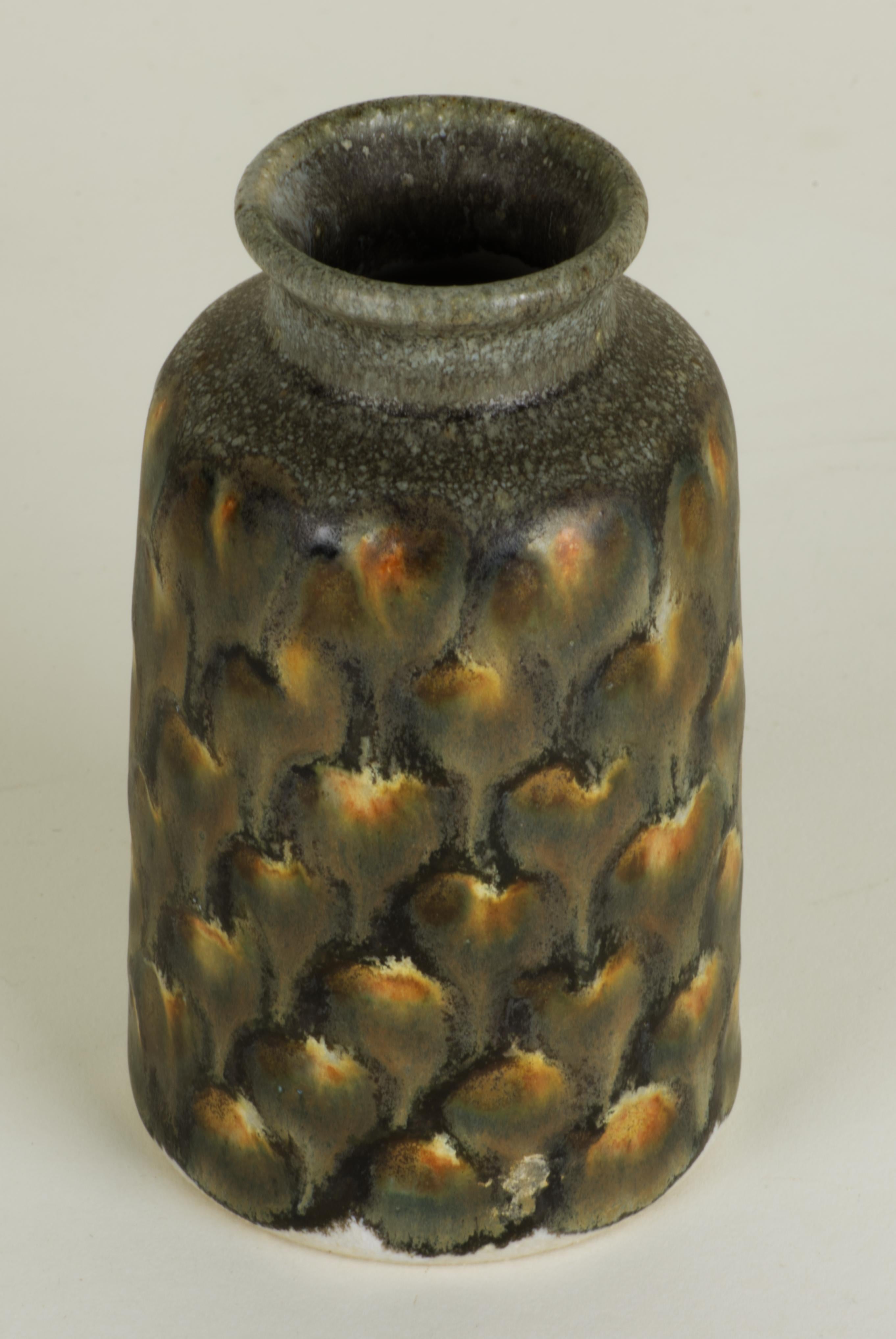  Small glazed stoneware vase is made by North Carolina's Outer Banks studio of Jim Fineman. It is decorated in his characteristic Peacock glaze done in warm brown and yellow palette, giving the vase an organic, earth toned appearance; the bottom is