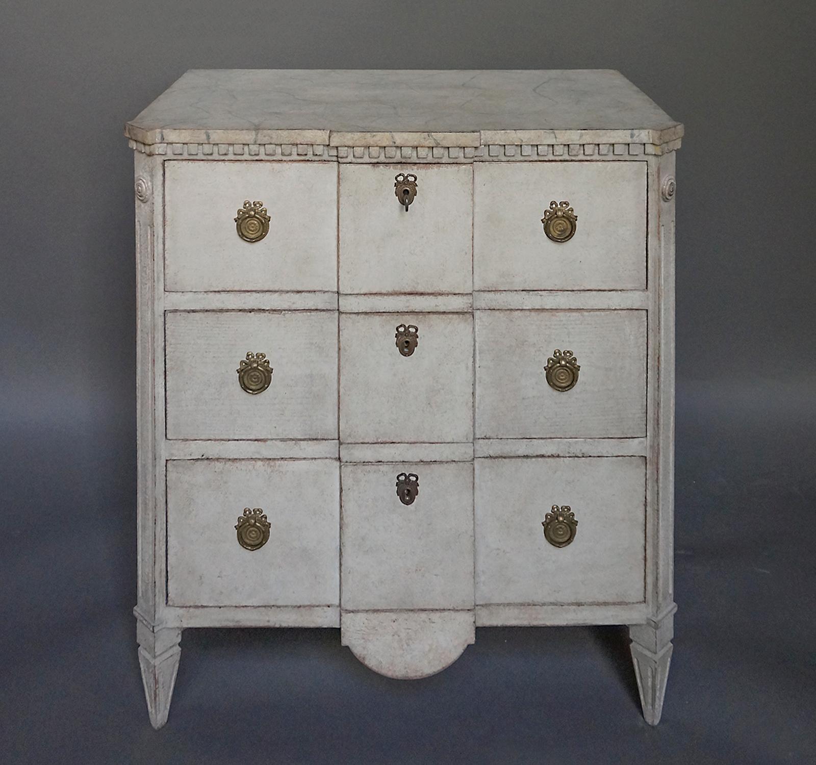 Swedish commode, circa 1860, with block front and shaped apron. The top is painted with a green marble pattern and has decorative dentil molding below. The three drawers lock with a single key, and the canted corner blocks terminate in tapering