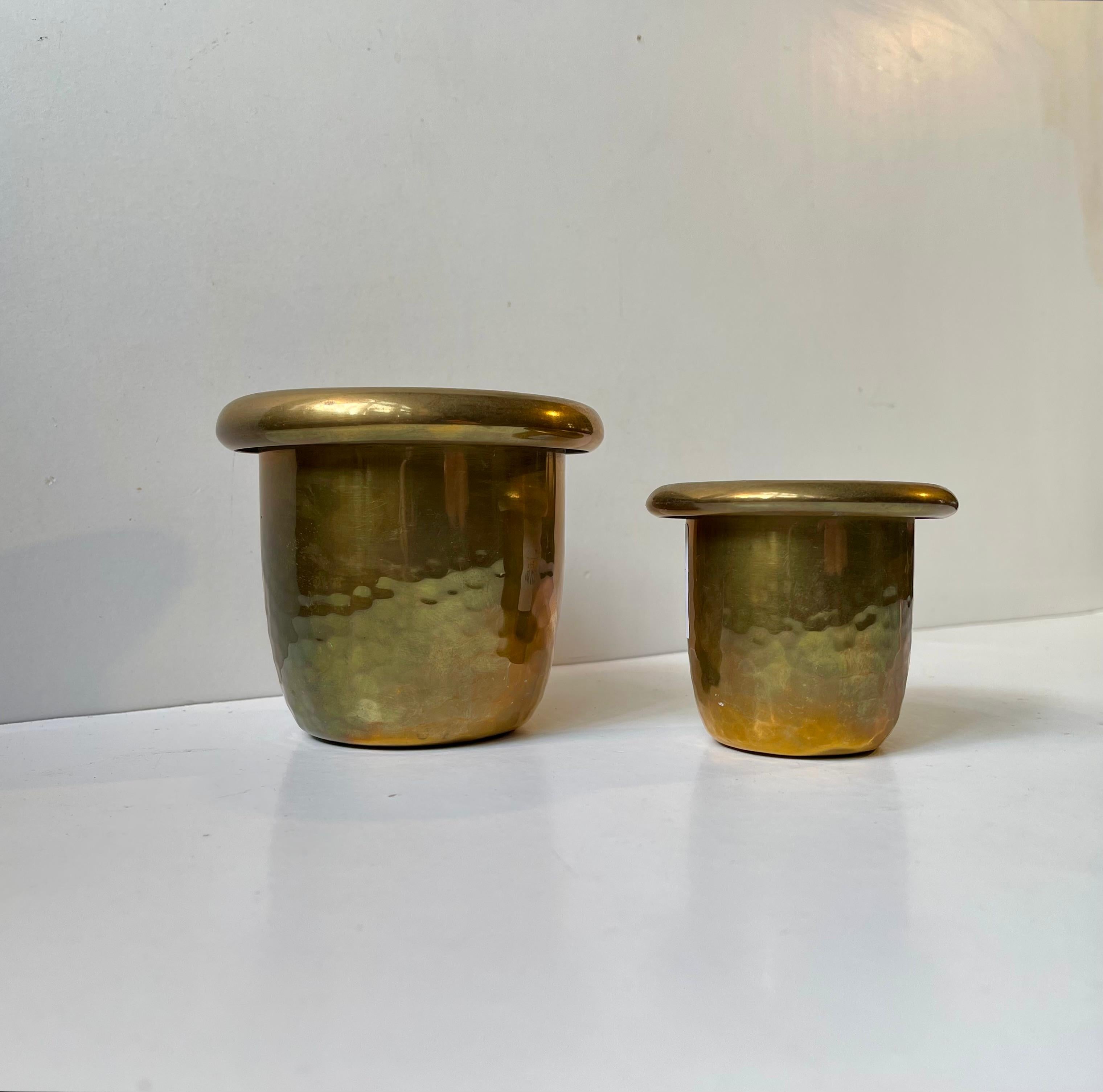 A set of small planters in hammered brass featuring folded edges. Both stamped by an unknown Swedish maker circa 1920-50. Stylistically this small pair is very much in line with the Swedish Grace movement. 

Measurements: H: 9/7 cm, D: 11/8.5