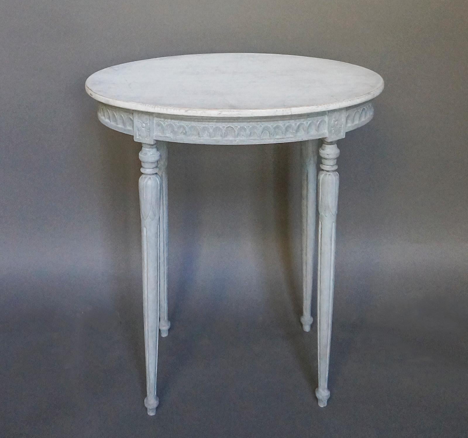 Oval table, Sweden circa 1880, in the Gustavian style. The apron is ringed with lambs-tongue molding between the corner blocks with their carved rosettes. The tapering legs have acanthus leaf detail below a section of delicate turnings. A graceful