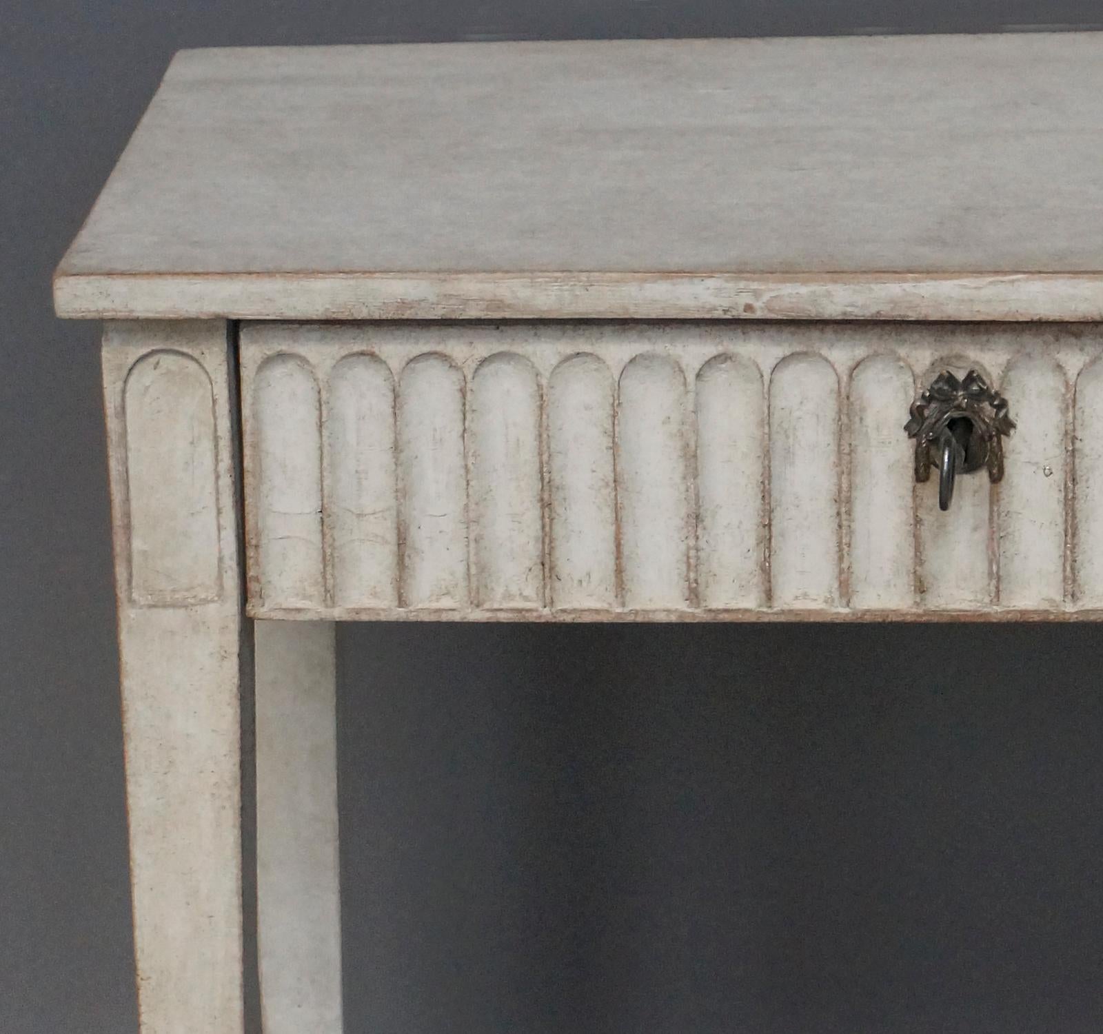 19th century side table with apron drawer, Sweden circa 1850. The full-width apron drawer with recessed lambs-tongue carving. Tapering square legs.