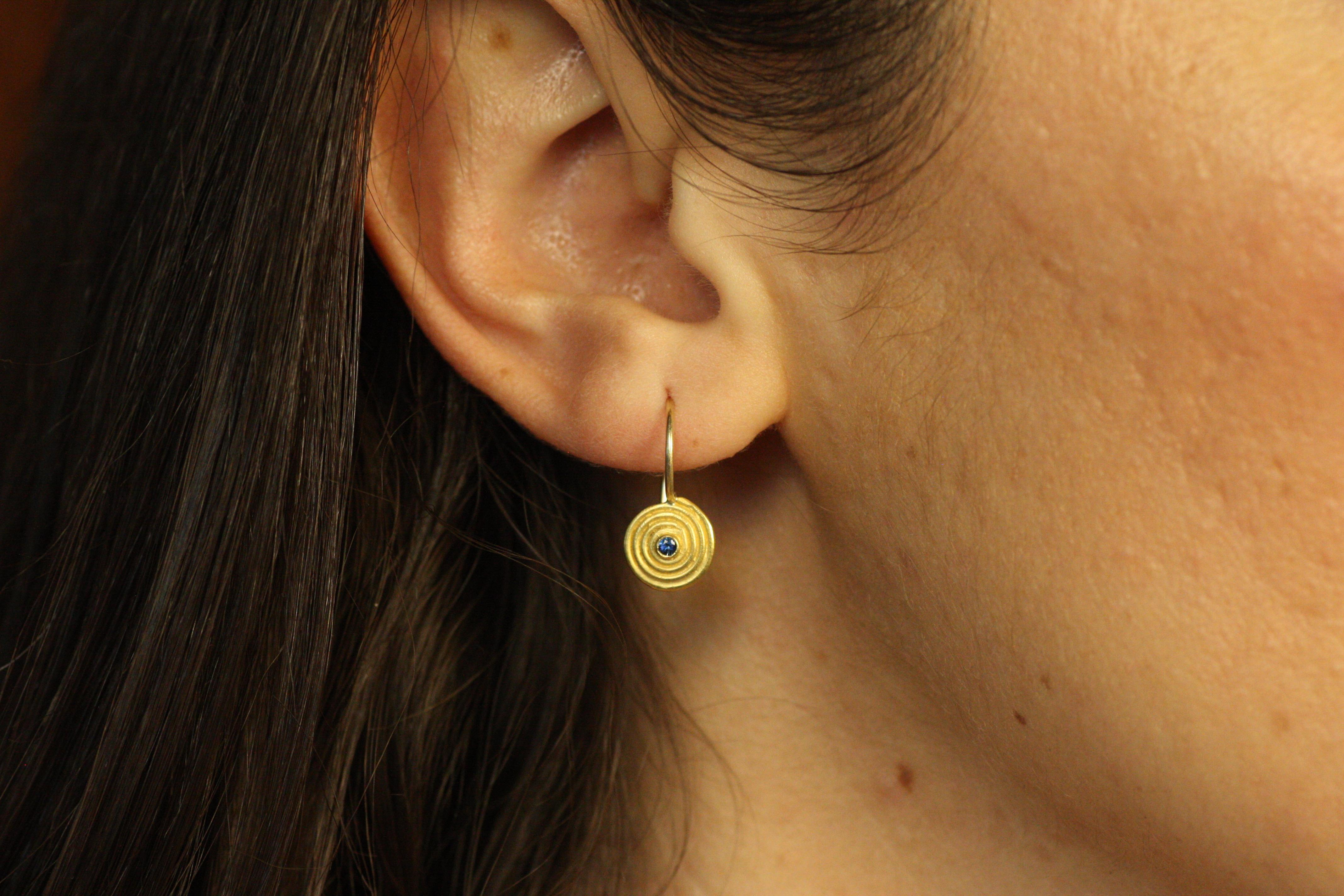 Channel timeless beauty with these small Swirl Earrings featuring brilliant blue sapphires nestled in 22K yellow gold. The handcrafted spiral design reflects ancient aesthetics, making these earrings a versatile and elegant choice for any