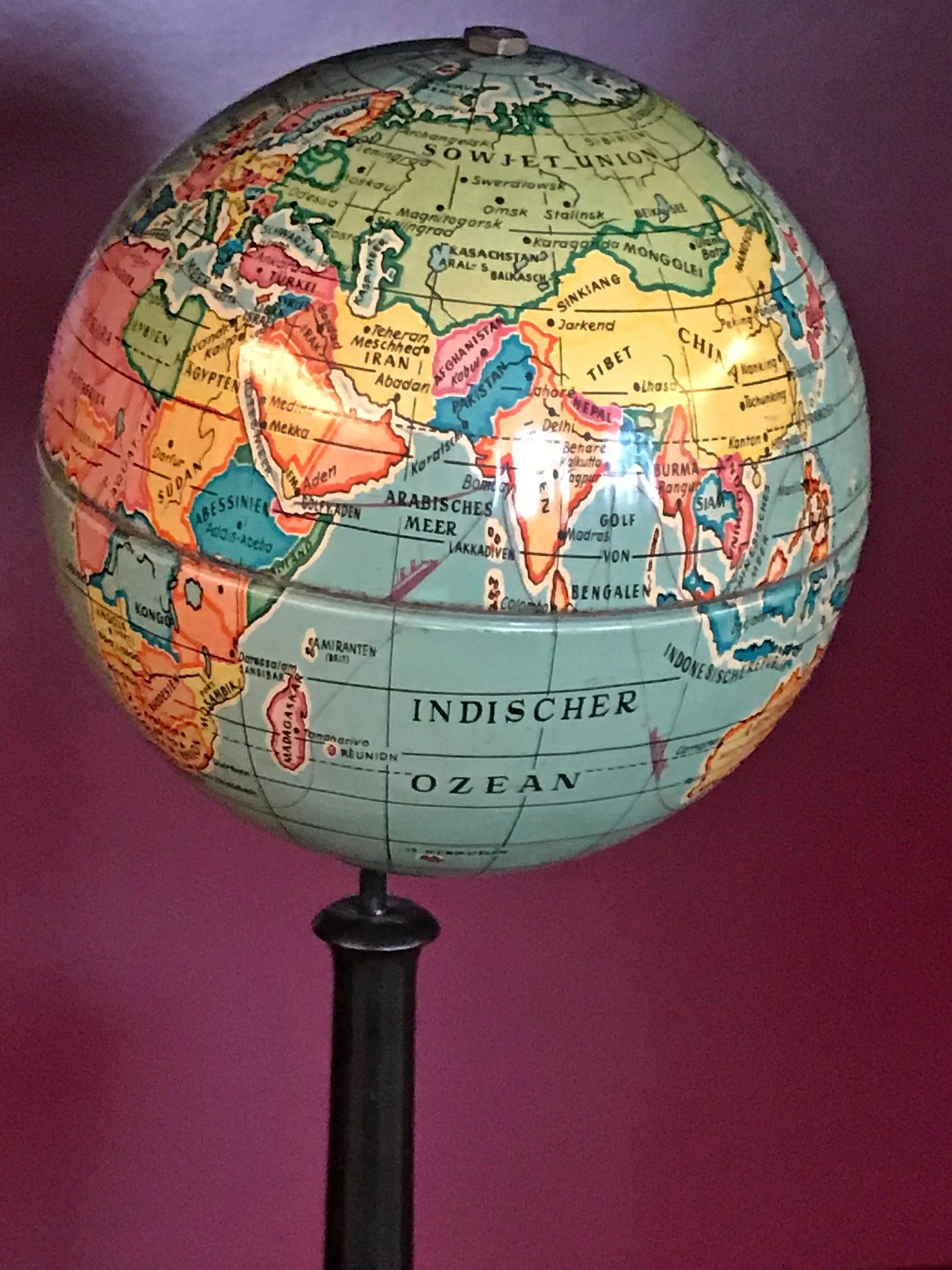 Small table globe made of metal, without manufacturer's declaration

The globe is hard to date because it has countries and names that did not exist together.

At the equator there might have been another ring with continuous friction marks. The