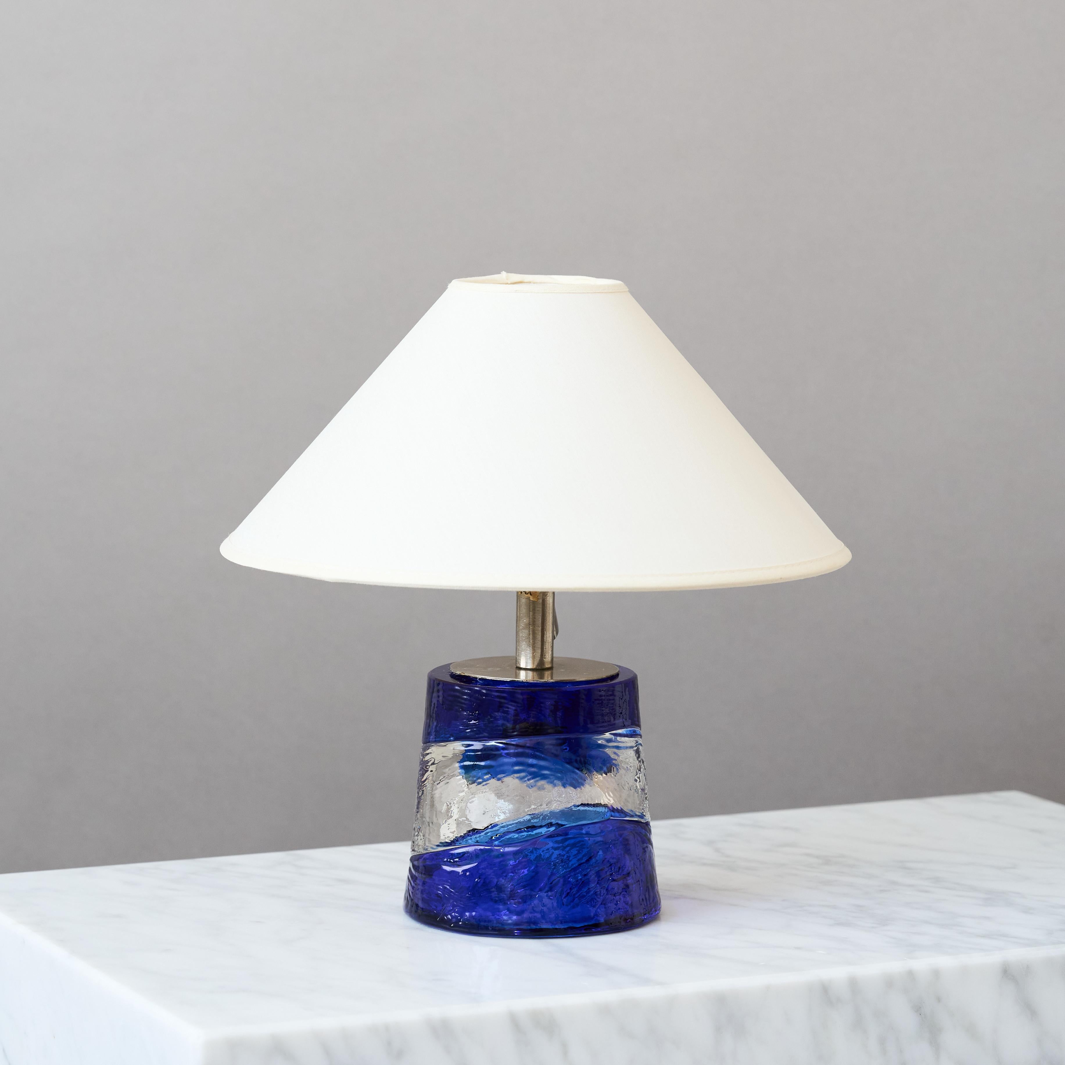 Una preciosa lámpara de sobremesa de mediados de siglo con una increíble base de cristal azul y transparente hecha a mano.
Fabricada por Paul Kedlev para Reijmyre Glasbruk, Suecia, años sesenta.

Gran estado original. Firmado en la base. 

Se vende