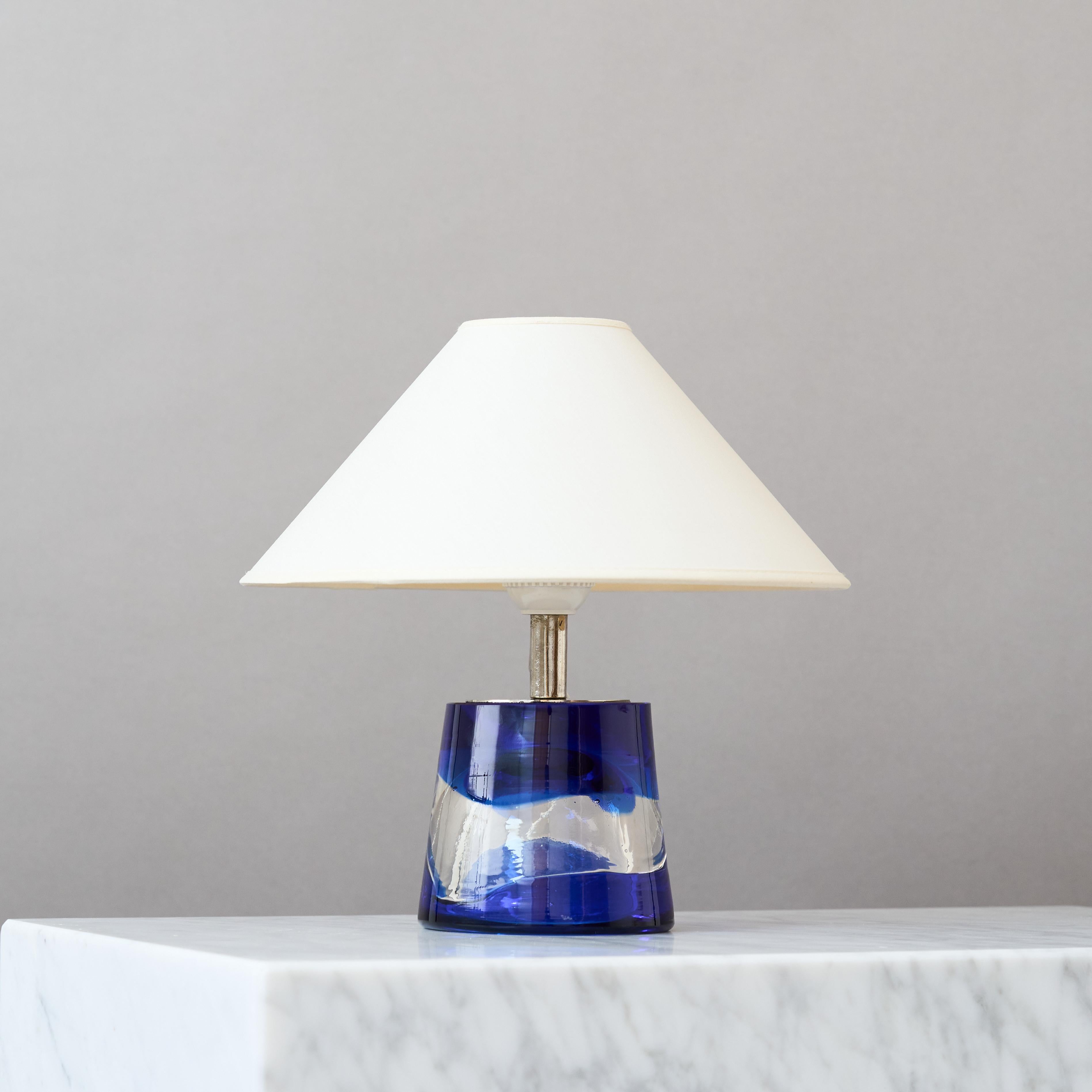 Una preciosa lámpara de sobremesa de mediados de siglo con una increíble base de cristal azul y transparente hecha a mano.
Fabricada por Paul Kedlev para Reijmyre Glasbruk, Suecia, años sesenta.

Gran estado original. Firmado en la base. 

Se vende
