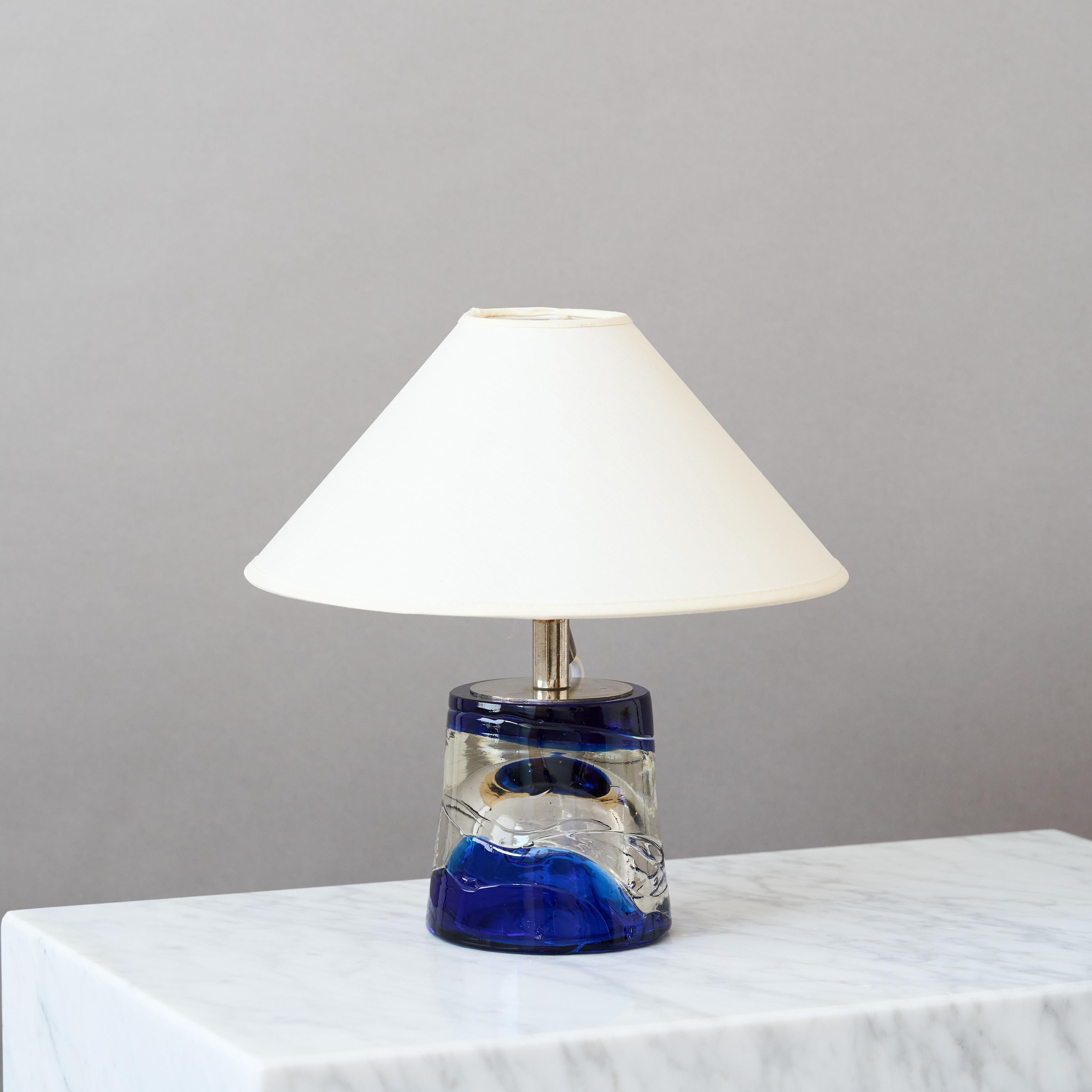 Una preciosa lámpara de sobremesa de mediados de siglo con una increíble base de cristal azul y transparente hecha a mano.
Fabricada por Paul Kedlev para Reijmyre Glasbruk, Suecia, años sesenta.

Gran estado original. Firmado en la base. 

Se vende