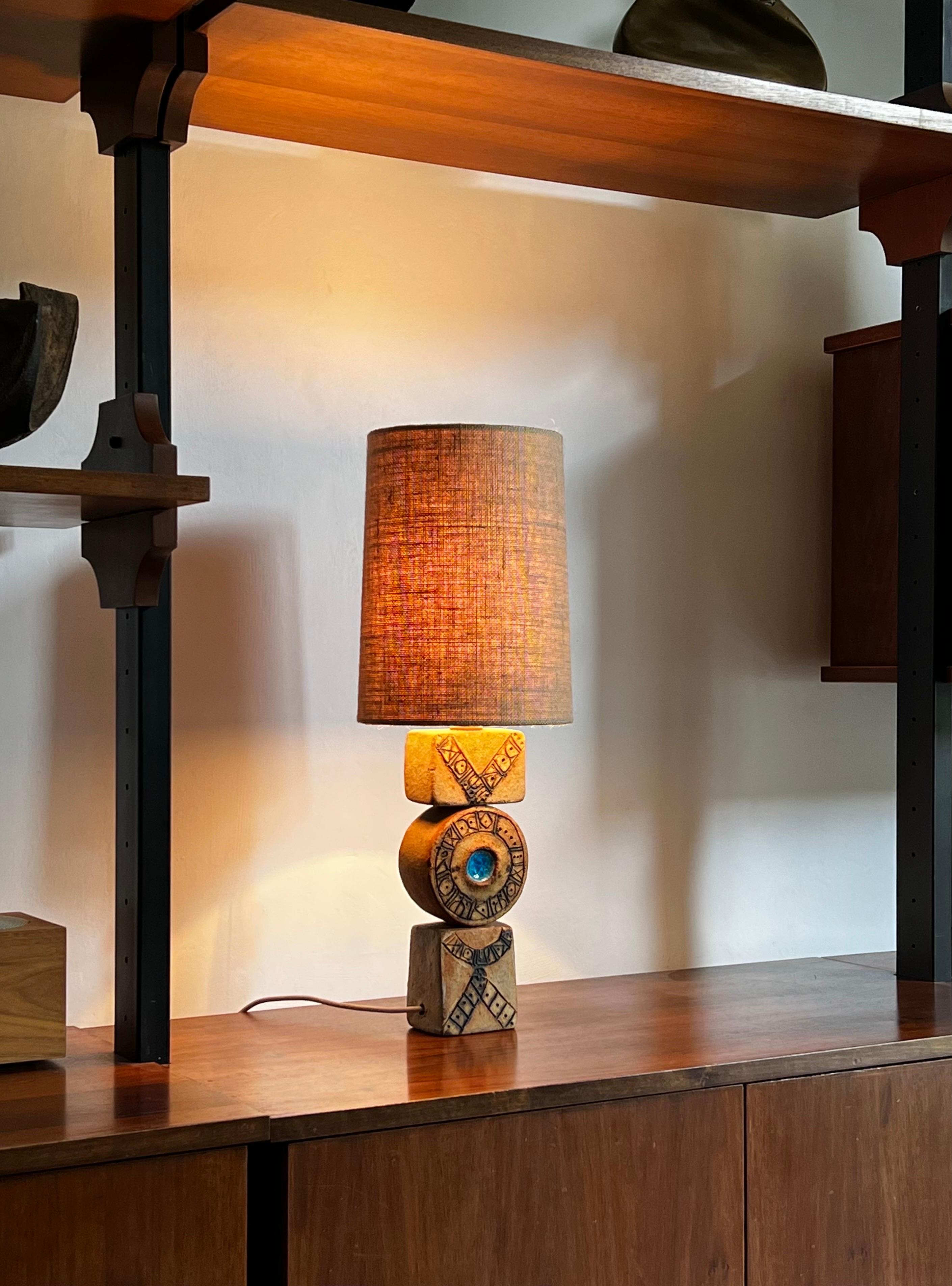 A small table totem lamp by ceramicist Bernard Rooke - double-sided - featuring Rooke's hieroglyphics and blue glass detail. Late 1960s, England.

The lamp is in nice original condition with particularly clear markings and even execution, while