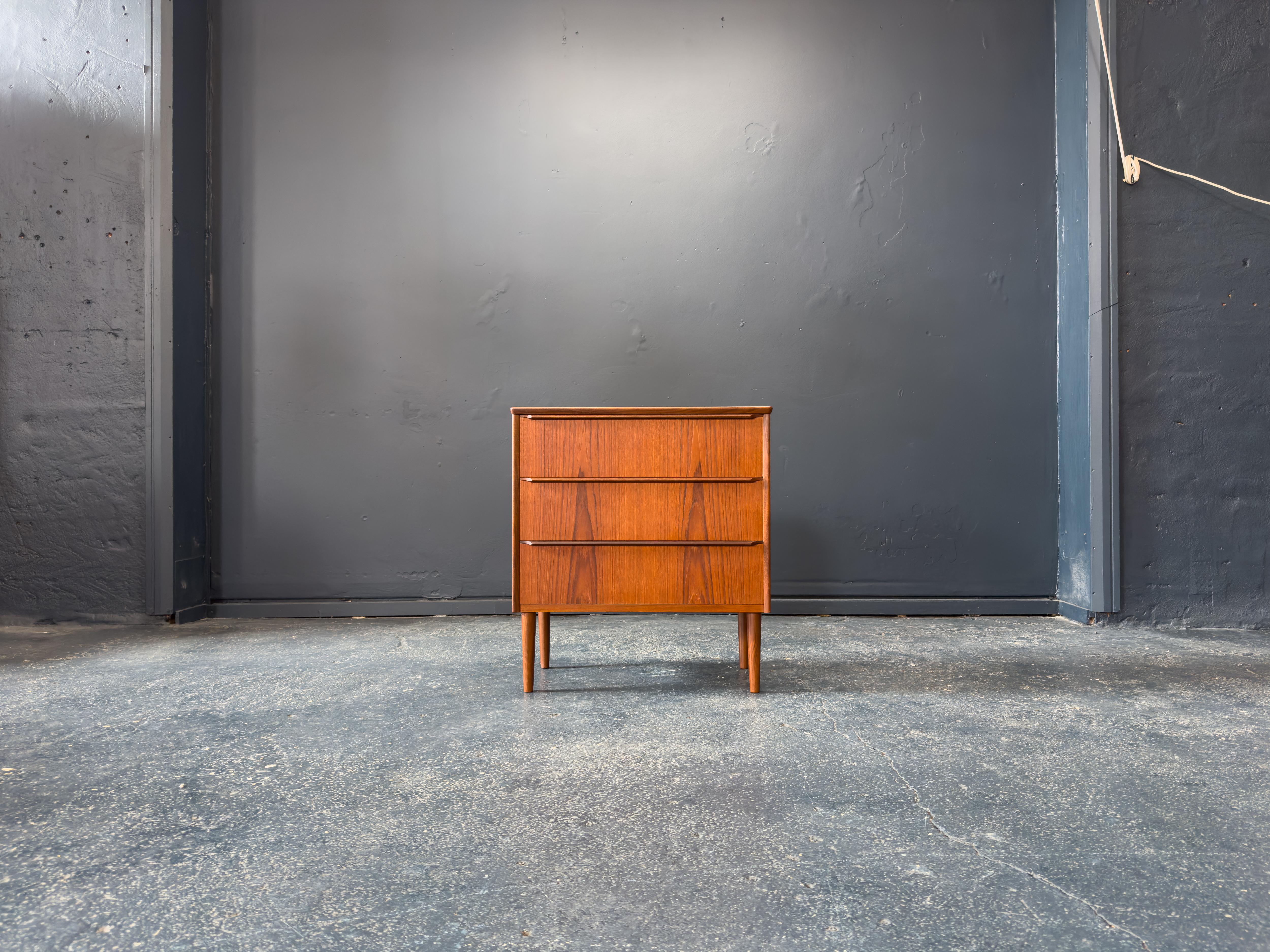 Questa affascinante cassettiera compatta in teak presenta linee pulite, proporzioni pratiche e una squisita lavorazione artigianale. Realizzato in pregiato legno di teak, il pezzo vanta una calda venatura color miele e linee verticali che ne