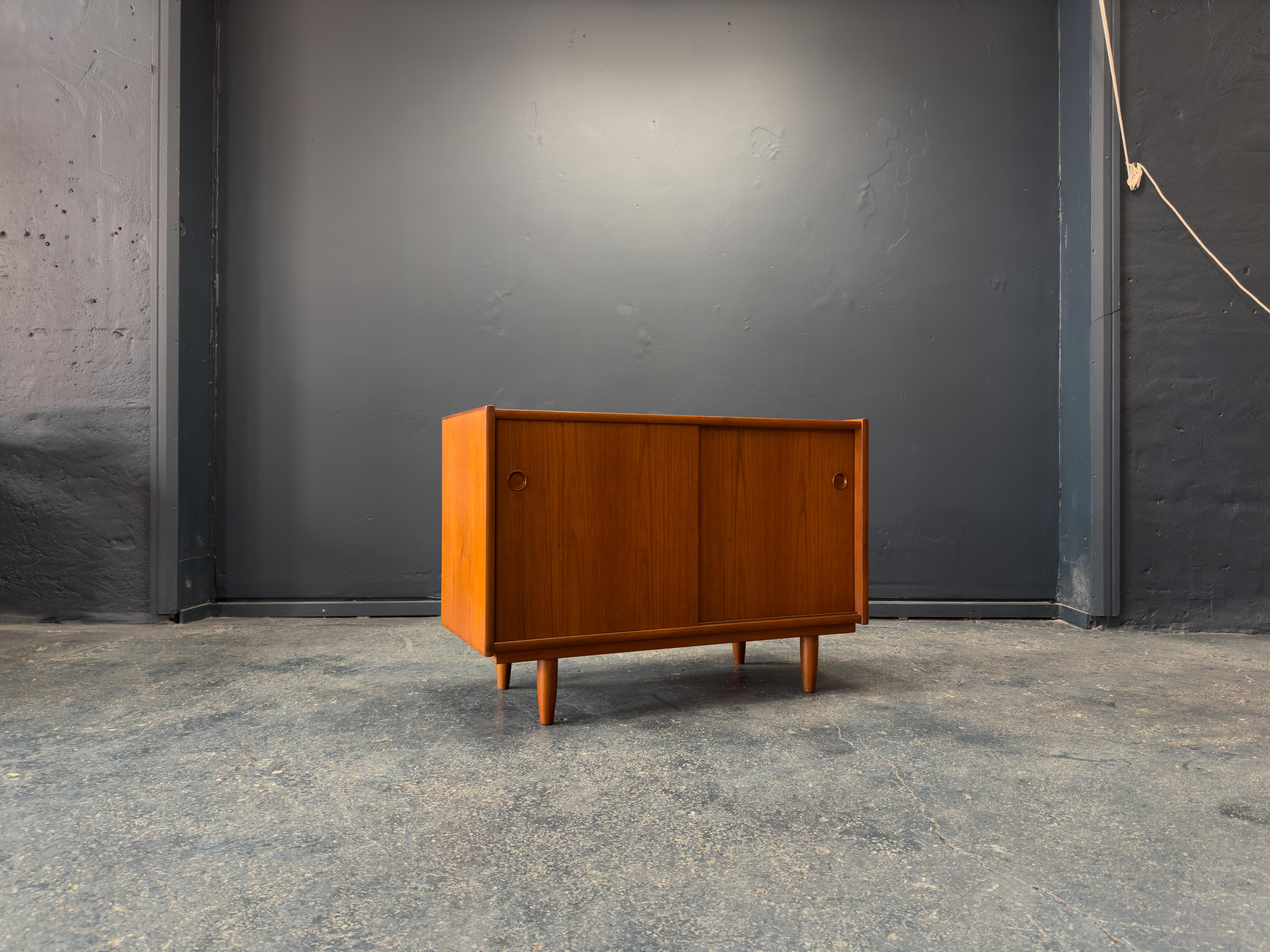 This beautifully crafted teak sideboard is made from rich, finely grained teak, the piece showcases smooth, clean lines and an understated aesthetic that celebrates the natural beauty of the wood.

The design features sliding doors with recessed